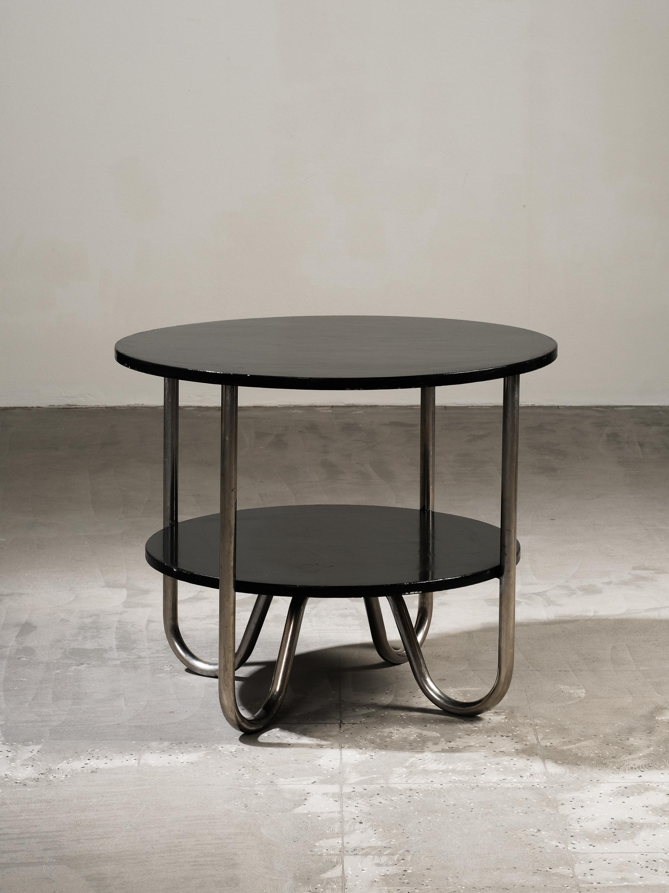 Beistelltisch aus Stahlrohr im funktionalistischen Bauhaus-/Art-Deco-Stil aus den 1930er Jahren. Zweistufiges Modell. Hergestellt in Schweden.

Der verchromte Stahl ist leicht oxidiert und die Tischplatten sind schwarz lackiert. Die Konstruktion ist