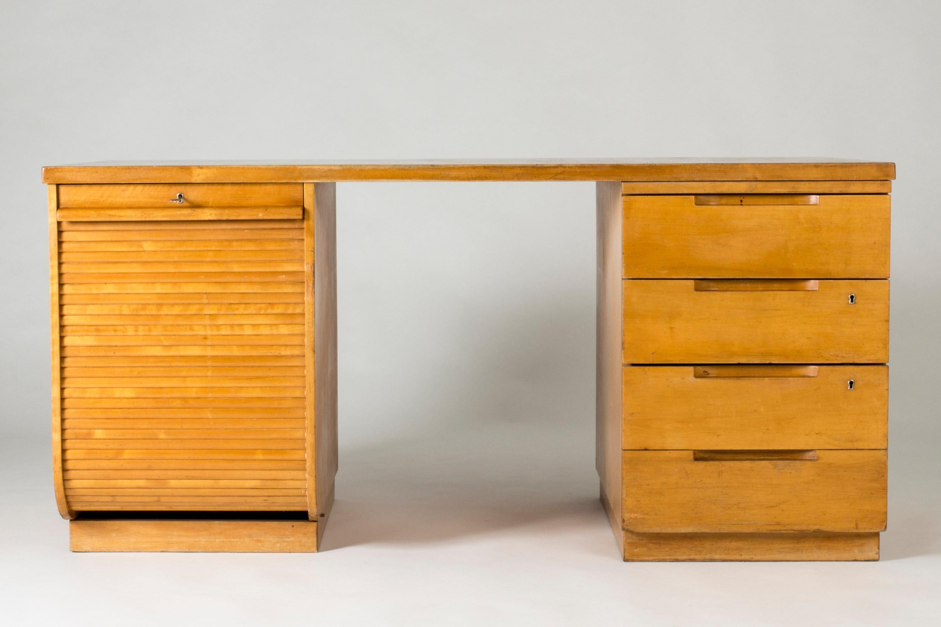 Striking desk by Alvar Aalto, made from birch in a compact functionalist design. Drawers to the right and a filing cabinet to the left with a jalousie door.

Ink spots inside the top drawer.