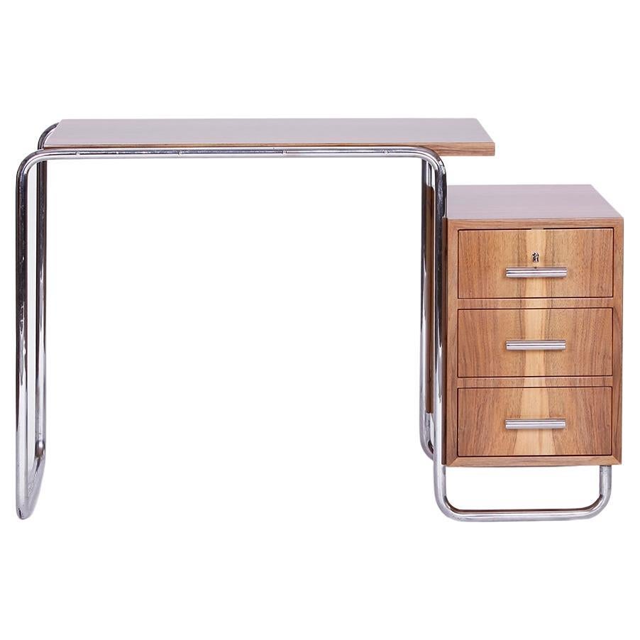 This functionalist desk, with a construction of bent tubular steel was made in Czech Republic during the 1930s. The original chrome has been polished and is in very nice condition with a great patina. 
The desk container with 3 drawers and the