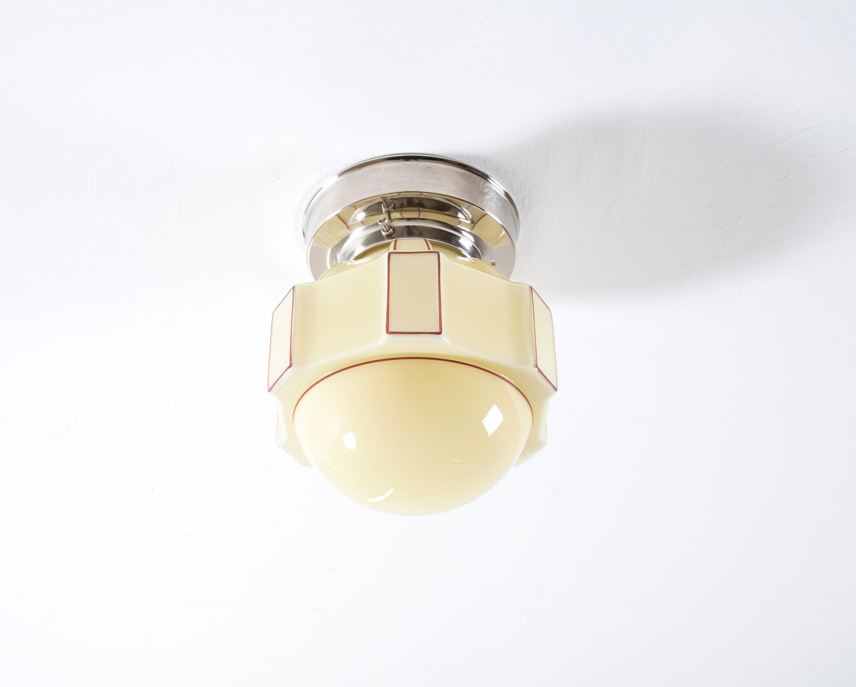 Sculptural and decorative ceiling light in opaline glass with chrome metal base. Designed and made in Norway from ca 1950s first half. The lamp is fully working and in very good vintage condition. It is fitted with one E27 bulb holder (works in the