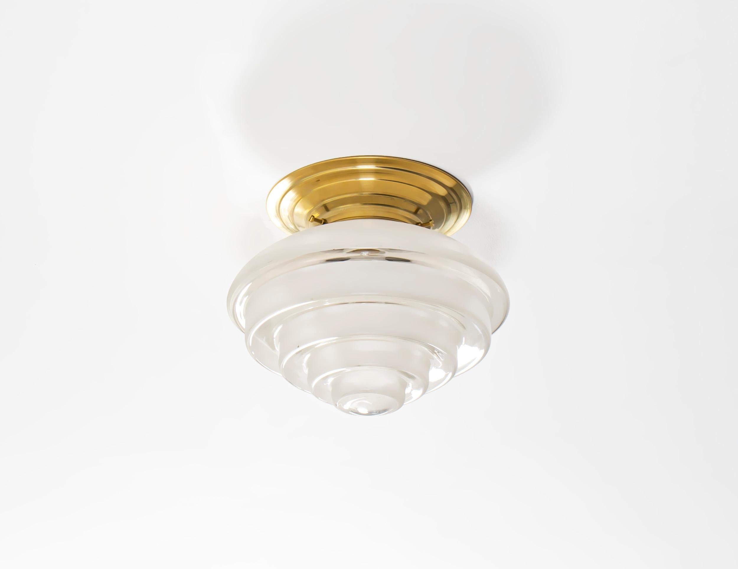 Wonderful and decorative ceiling light in glass with brass metal base. Designed and made in Norway from ca 1950s first half. The lamp is fully working and in very good vintage condition. It is fitted with one E27 bulb holder (works in the US) and