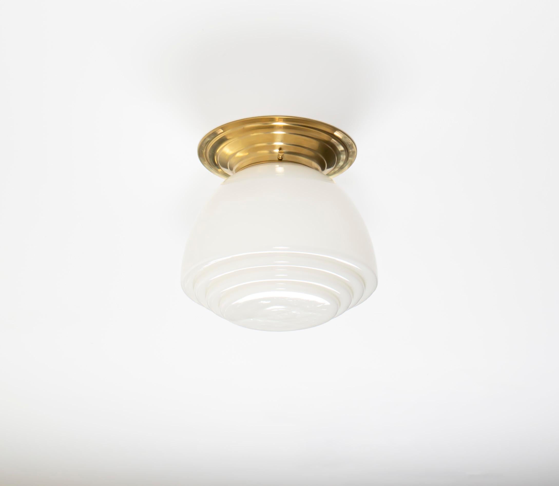 Wonderful ceiling light in with a opaline glass shade and base in brass base. Designed and made in Norway from ca 1950s first half. The lamp is fully working and in very good vintage condition. It is fitted with one E27 bulb holder (works in the US)