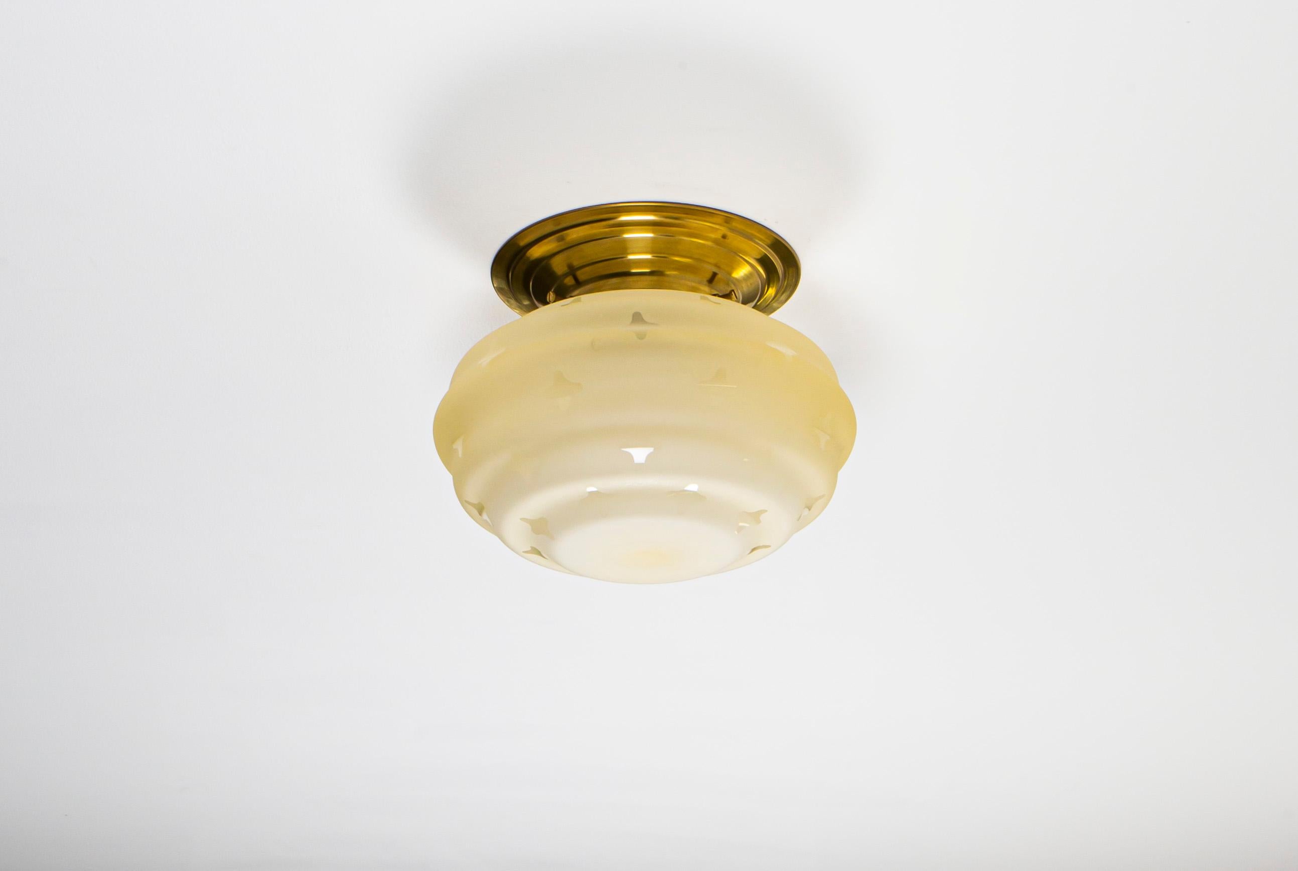 Decorative ceiling light with frosted glass shade and brass metal base. Designed and made in Norway from ca 1950s first half. The lamp is fully working and in very good vintage condition. It is fitted with one E27 bulb holder (works in the US) and