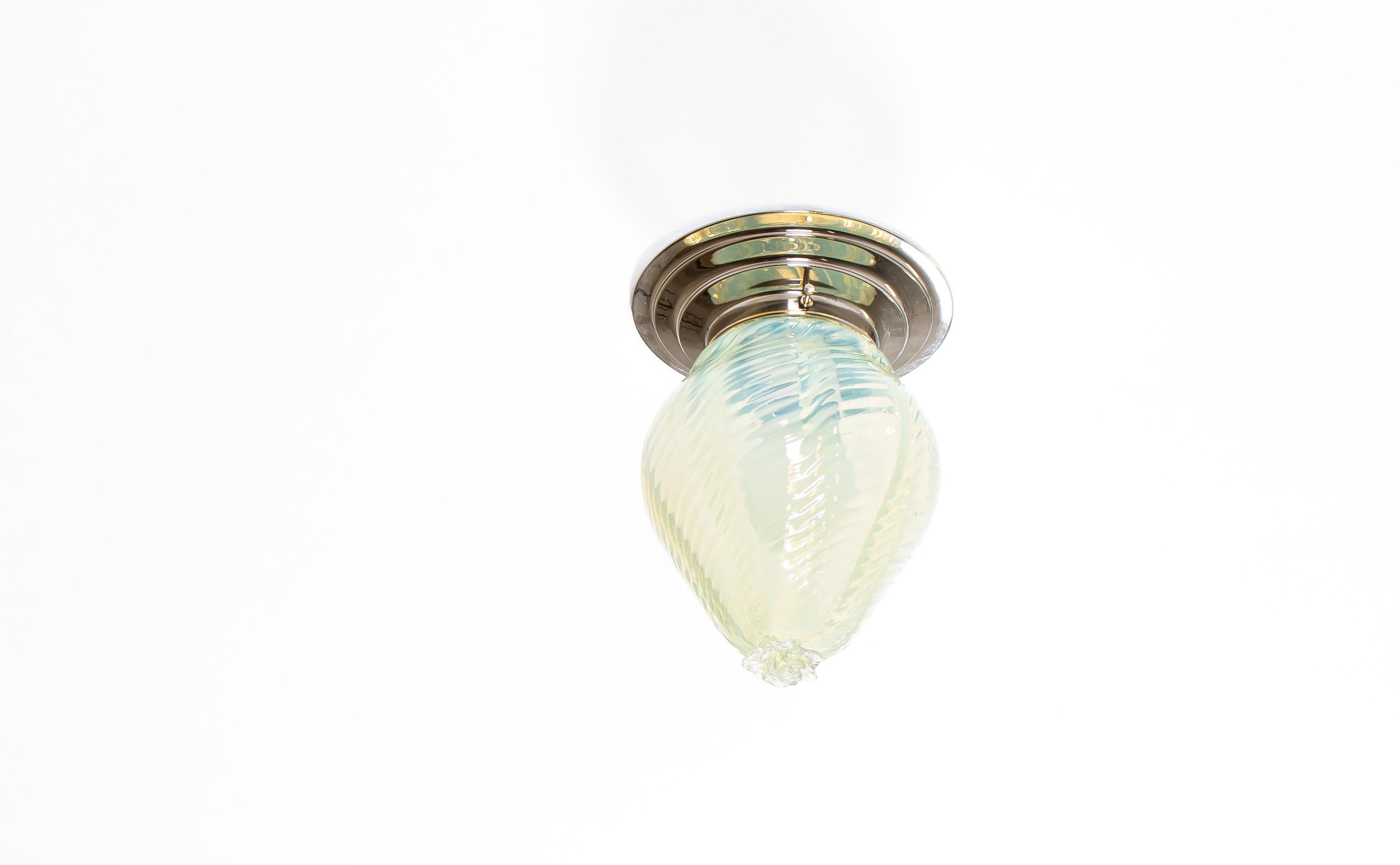 Decorative ceiling light in art-glass with chrome metal base. Designed and made in Norway from ca 1950s first half. The lamp is fully working and in good vintage condition. It is fitted with one E27 bulb holder (works in the US) and carries a max
