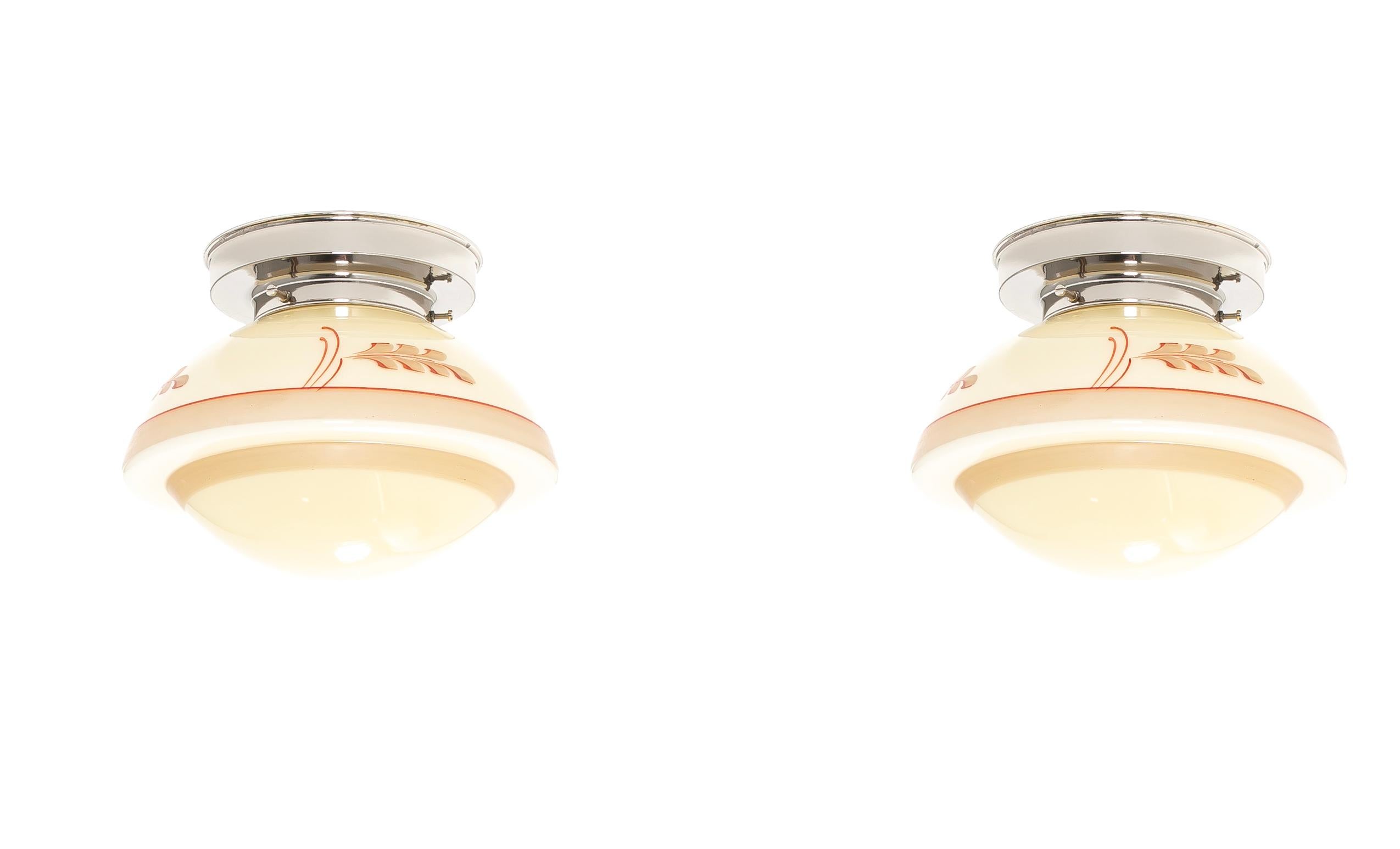 Wonderful and decorative ceiling lights with stenciled glass shade and base in chrome. Designed and made in Norway from circa 1950s first half. Both lamps are fully working and in good vintage condition. Each lamp is fitted with one E27 bulb holder