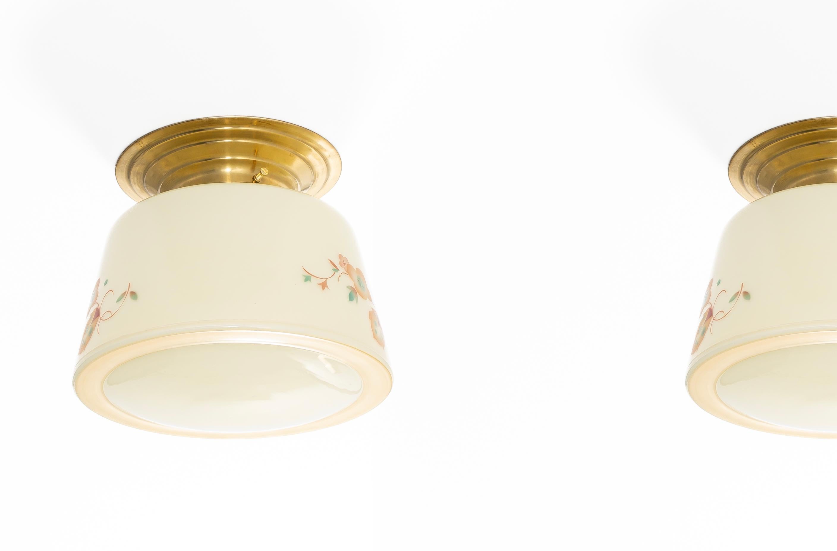 Wonderful and decorative ceiling lights with decorated glass shade and base in brass. Designed and made in Norway from circa 1950s first half. Both lamps are fully working and in good vintage condition. Each lamp is fitted with one E27 bulb holder