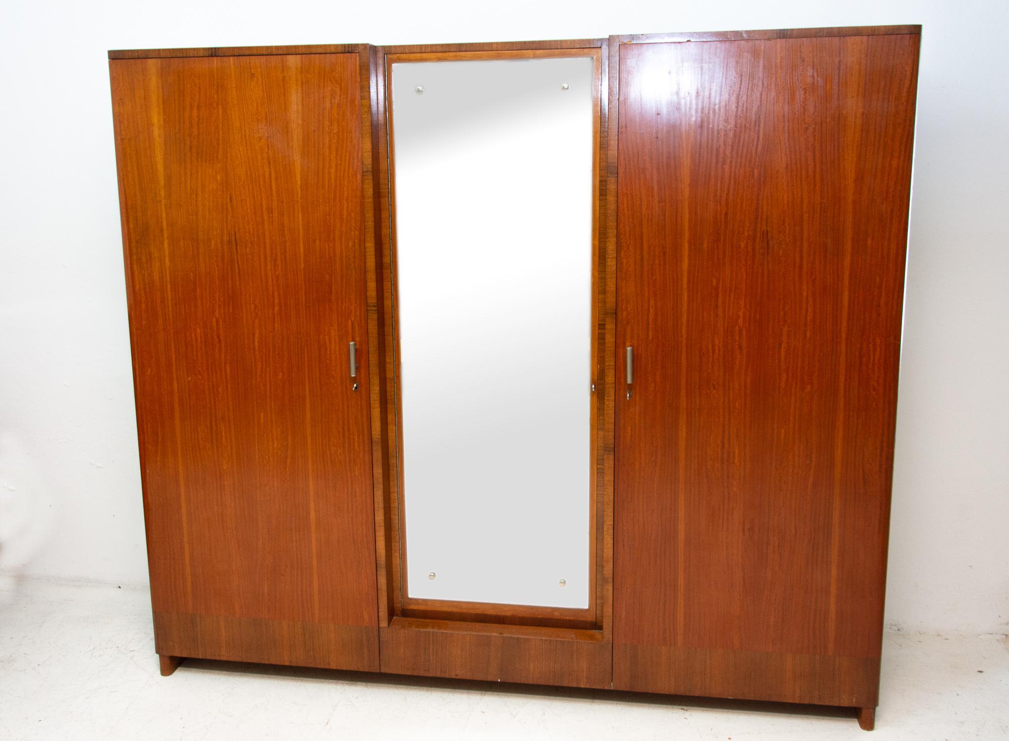 This elegant glassed wardrobe with an unusual internal arrangement was made in the 1930s as part of functionalist bedroom. It was designed by the prominent Prague architect Vlastimil Brožek. It is made of solid wood and is veneered in walnut. It