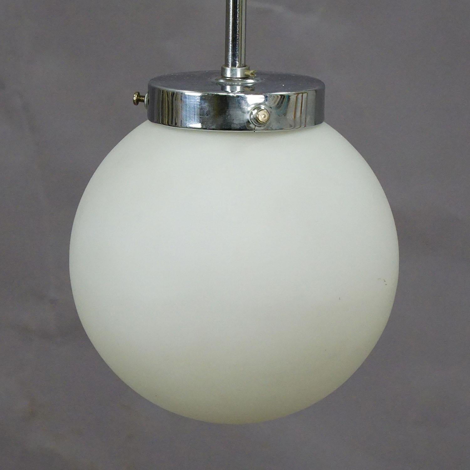 An antique Bauhaus style pendant lamp with a white opaline glass shade and chromium plated metal fitting. Cabling renewed, working order. With international E27 base lamp holder.

Measures: Height 22.05