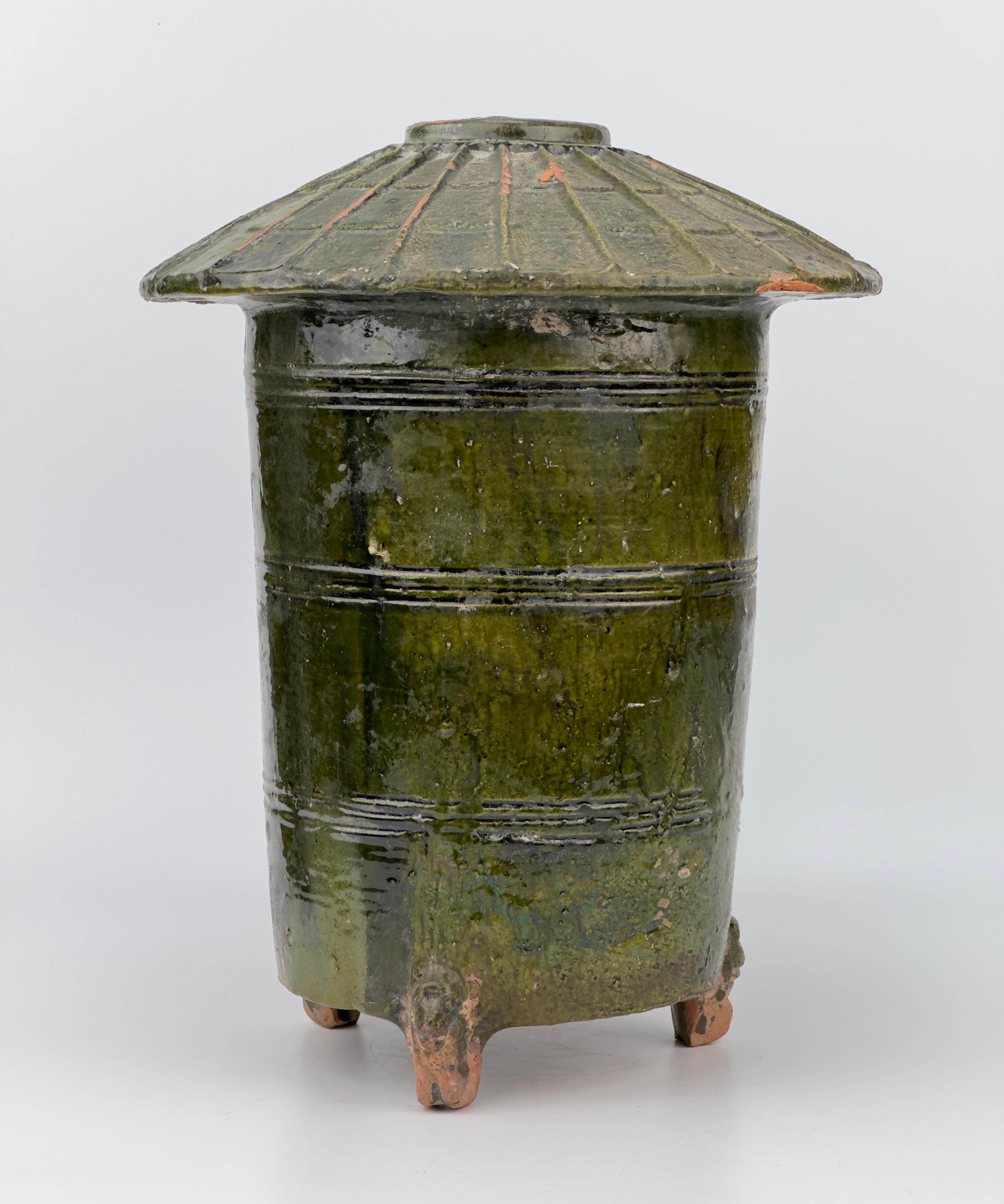 Cylindrical vessel on three animal-shaped feet (dragon or snake), wall with profile grooves, roof. Ceramic with green transparent glaze. 