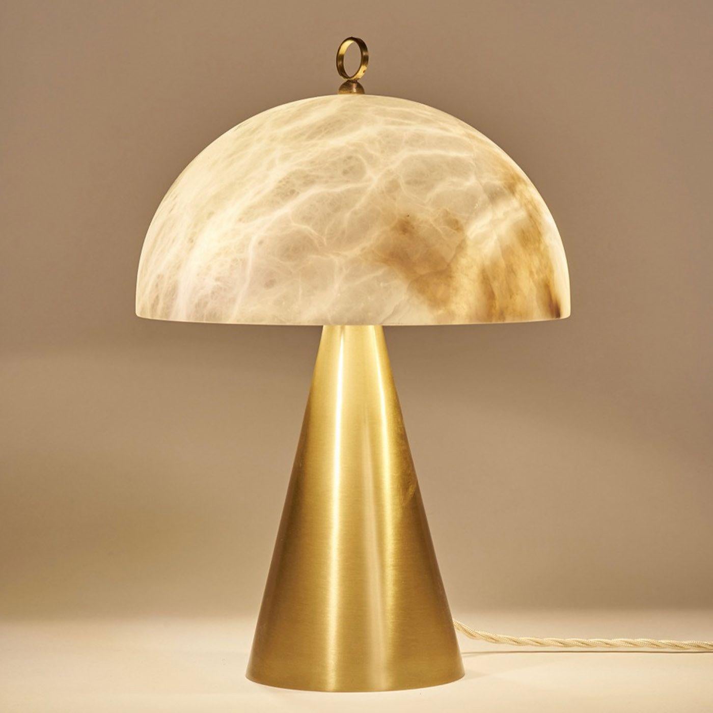 A small and compact table lamp composed of a conic brass base with a semi-spheric alabaster cover. It is suitable for bedside tables and wall cabinets. It is also available with inverted base and cover materials to match in the same ambience.