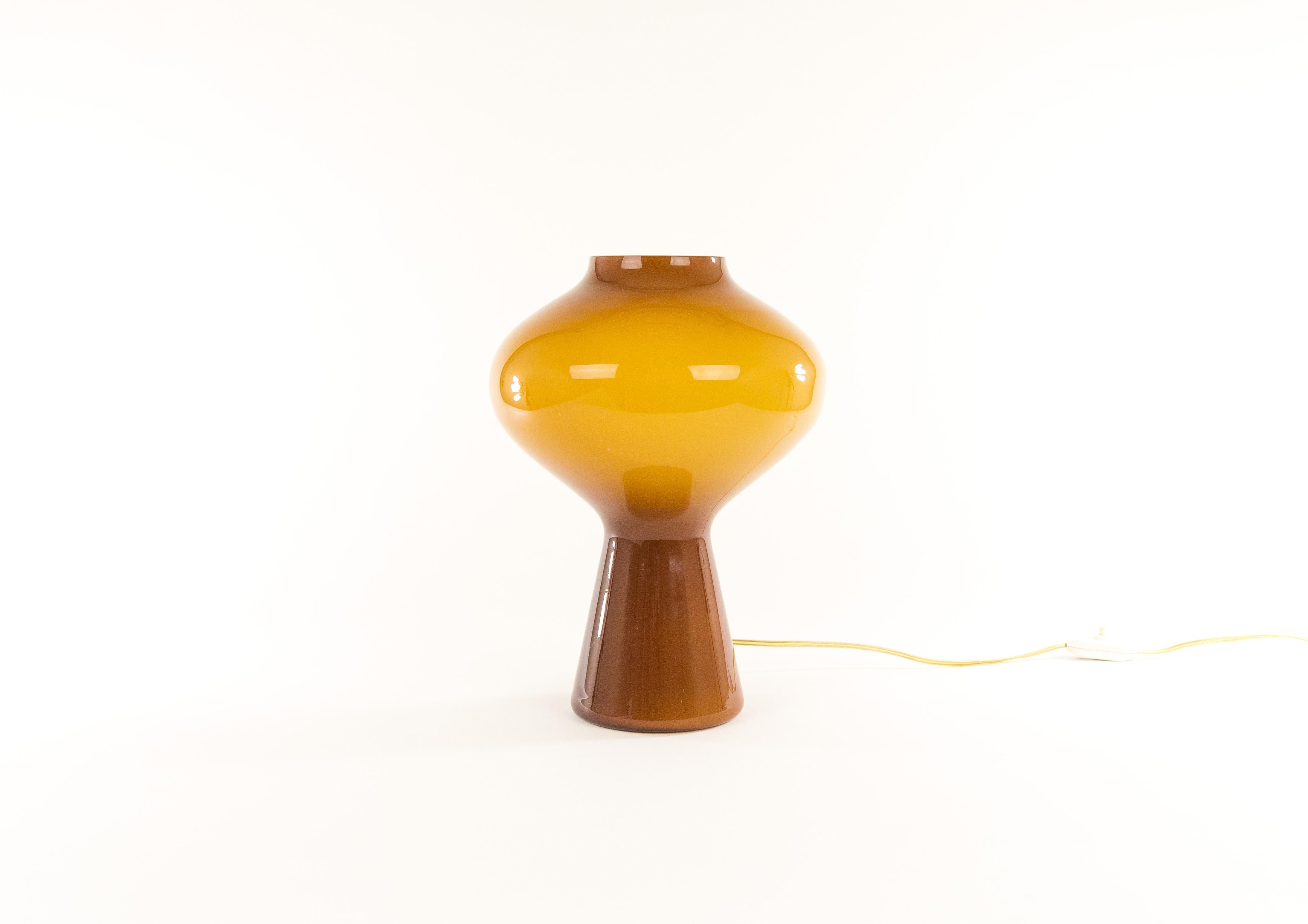 A hand blown amber colored glass Fungo table lamp designed by Massimo Vignelli at the start of his impressive career in design and executed by Murano glass specialist Venini.

These lamps were made in various sizes: this is the largest version. We