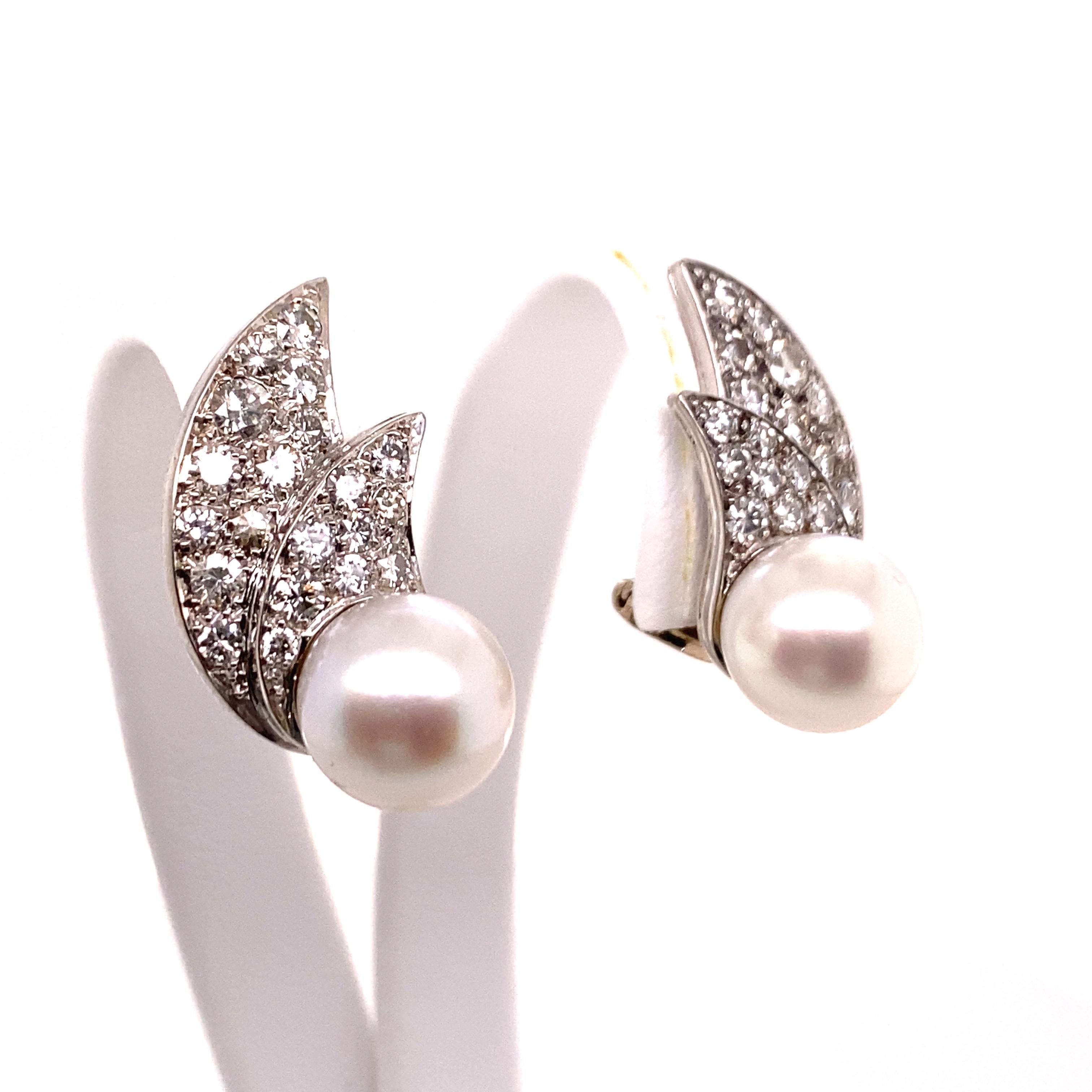 Funky cultured pearl and diamond ear clips in platinum 950. Designed as two double wings, grain set with 40 brilliant-cut diamonds totalling 0.80 ct. 

Approximate from the 1970s.

Dimensions approx.: 23.8 x 10.8 mm / 0.94 x 0.43 inches
