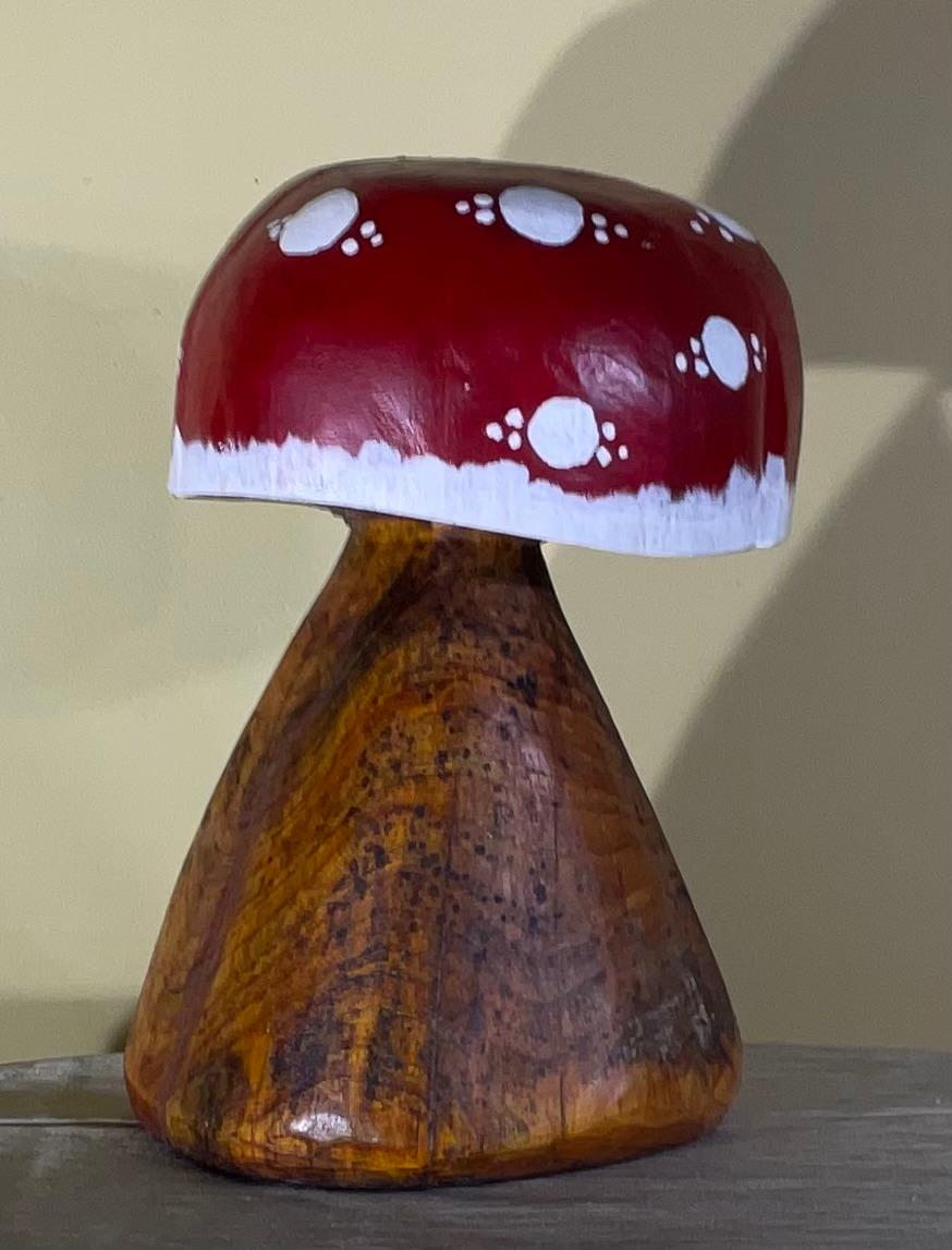 

Questa scultura di funghi unica e vivace è un bellissimo pezzo d'arte artigianale. Sapientemente intagliato nel legno di frassino, il fungo presenta una ricca venatura naturale che si integra con il cappello rosso dipinto a mano con pois bianchi.