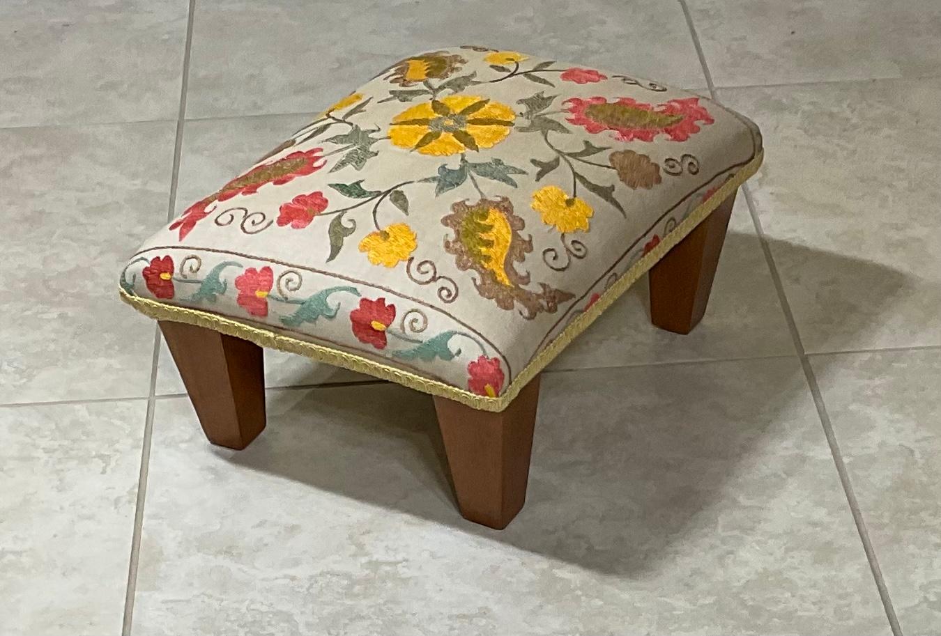 Elegant foot stool made wood, upholstered with beautiful vintage hand embroidery Suzani textile, decorative trimming all around, great decorative stool.
   