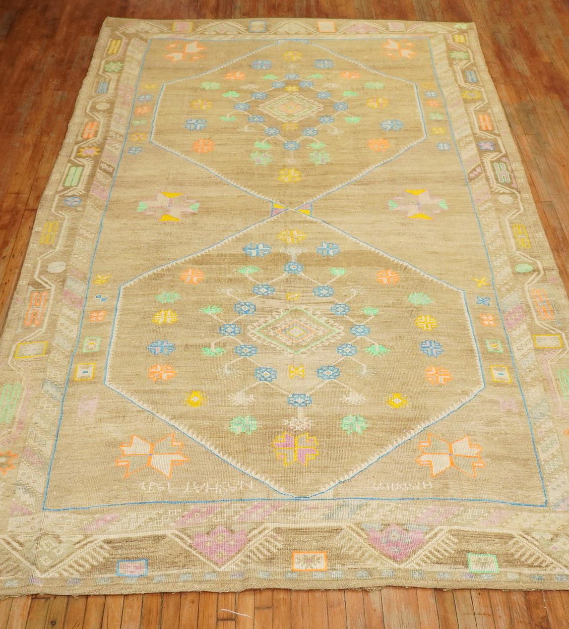 A one of a kind Boutique looking hand knotted room size vintage Turkish Kars rug featuring bright cotton accents in orange, yellow, lavender blue and neon green on a brown fieldhovered by 2 large geometric medallions. The accent colors were