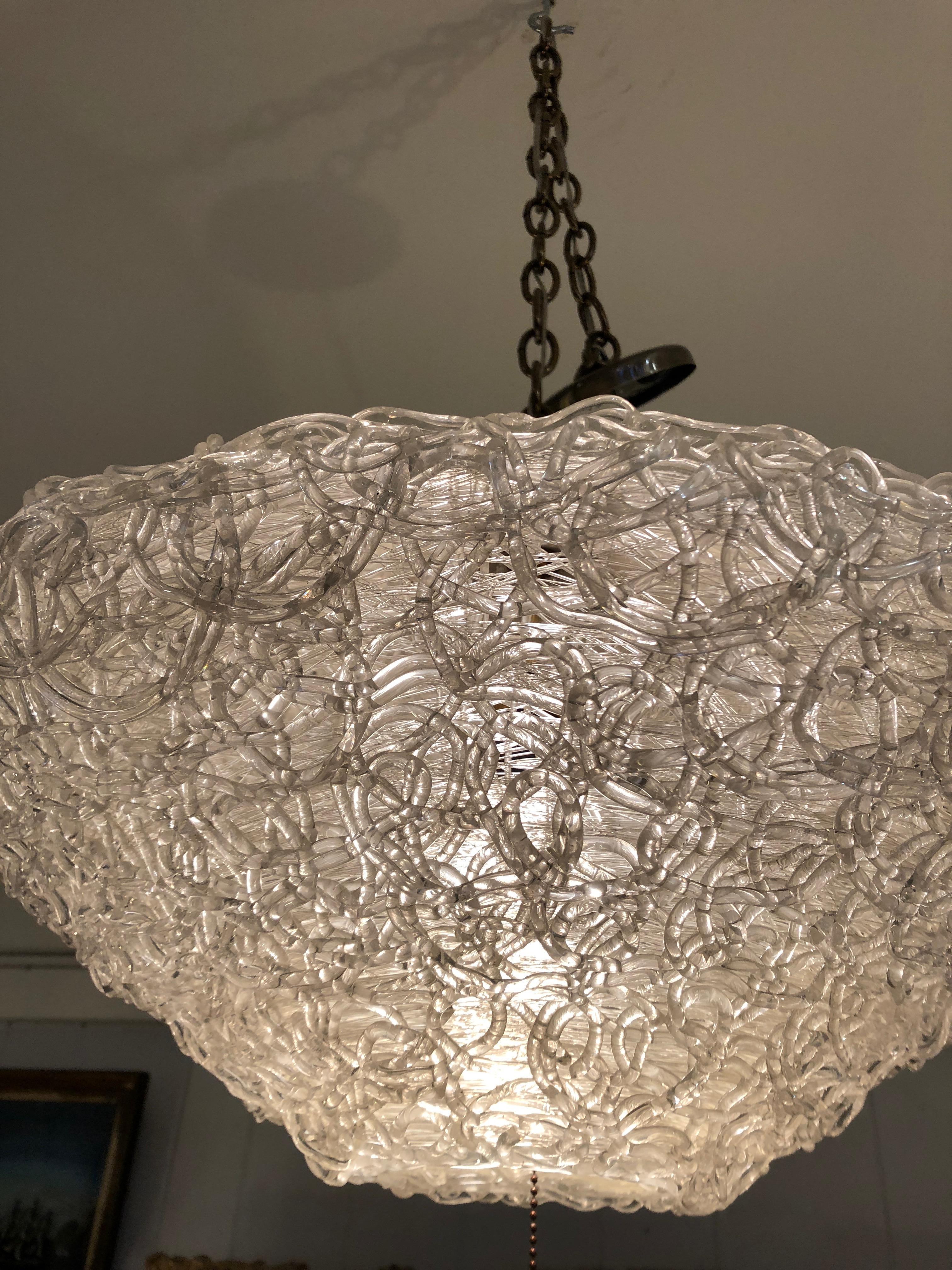 A cool rare find in a Mid-Century Modern light fixture, having a funky saucer shape and made of overlapping strings of glass called spagetti glass for obvious reasons.