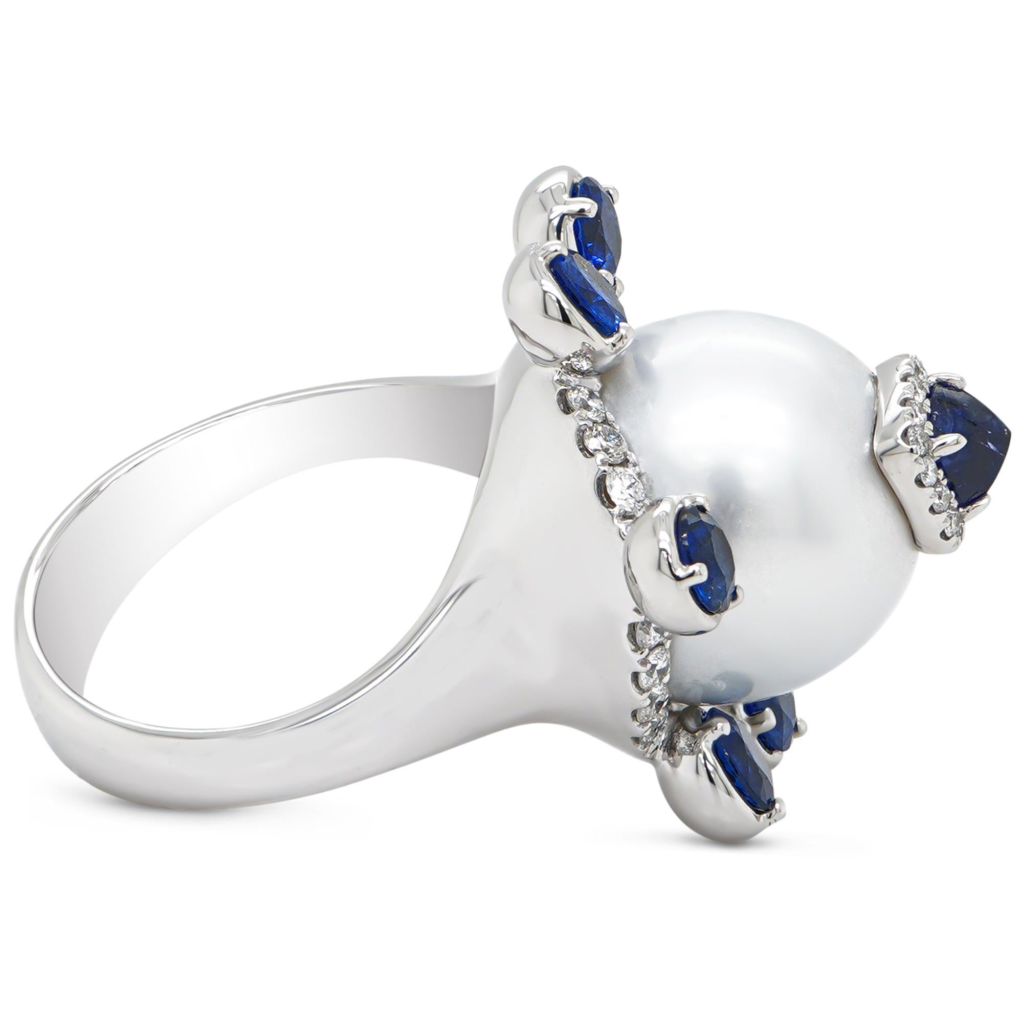 Possible only with meticuolous hand craft skill, this ring has been hand crafted in Hong Kong with utmost precision. A 13.40 mm south sea pearl is crowned with a sugar loaf no heat sapphire and accented with whiite diamonds on the side. The ring is