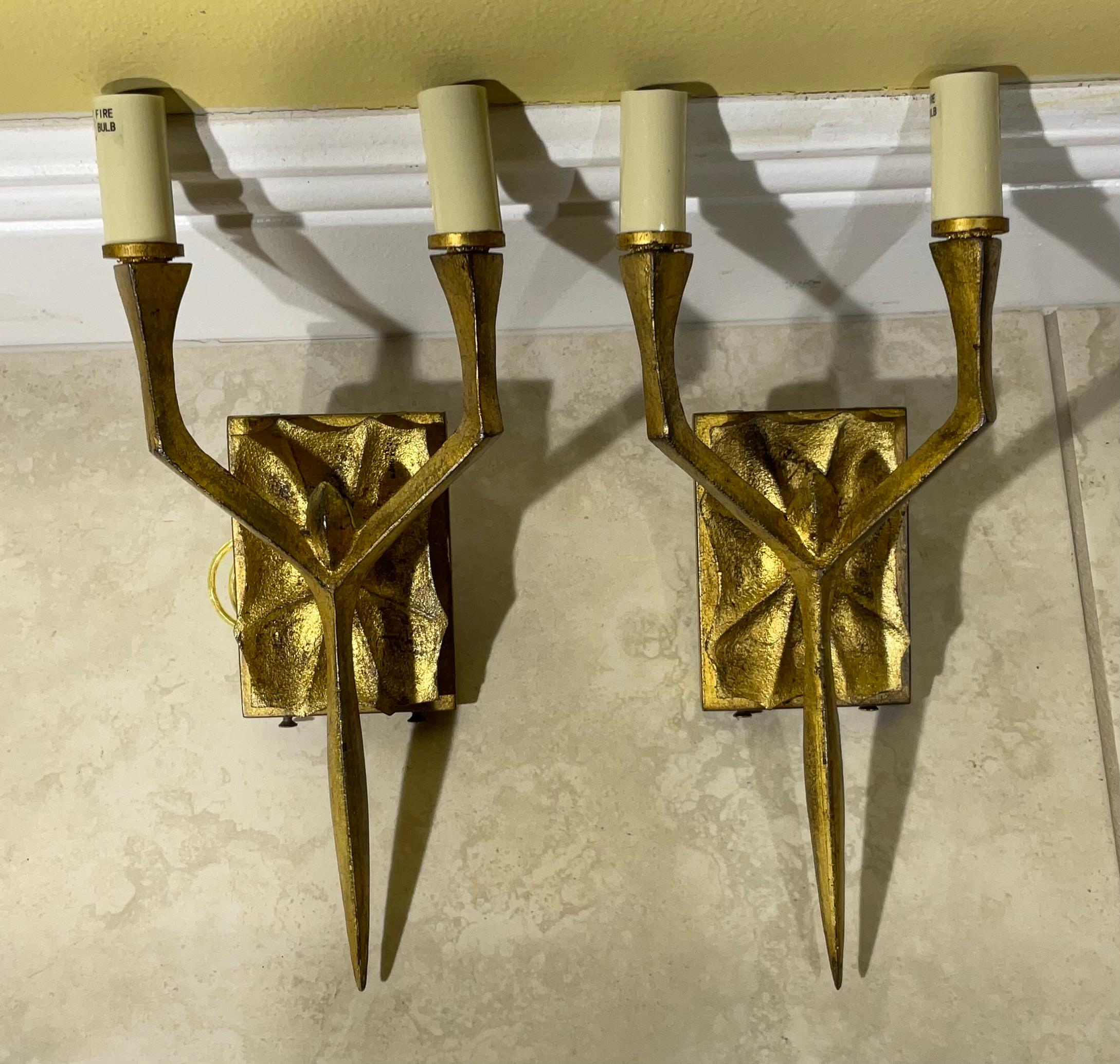 Pair of brutalist style wall sconces made of hand crafted iron , gold leaf color with two 60/watt light each . High quality craftsmanship, wired to fit US standards.