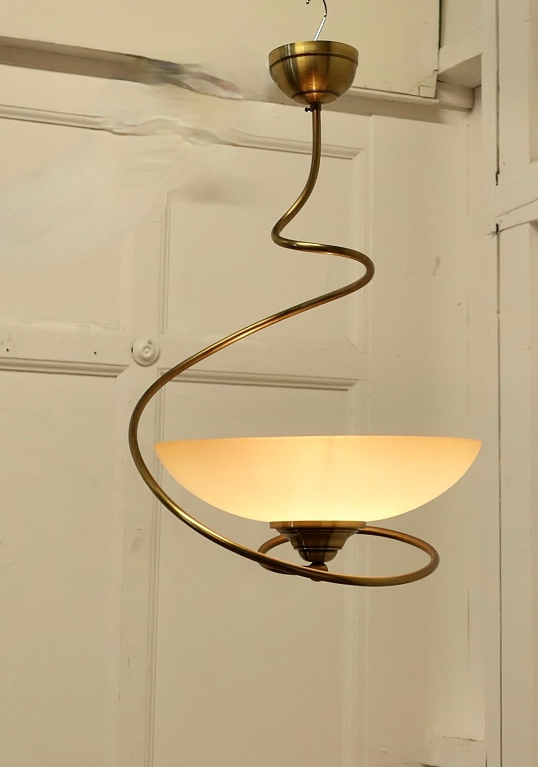 Funky Retro Corkscrew Spring Ceiling Light 

A Crazy piece, if you touch the lamp a little it spins and springs, a very unusual design from France and a handsome light 
The light has a honey tinted opaline shaded set in the twisted brass frame, it