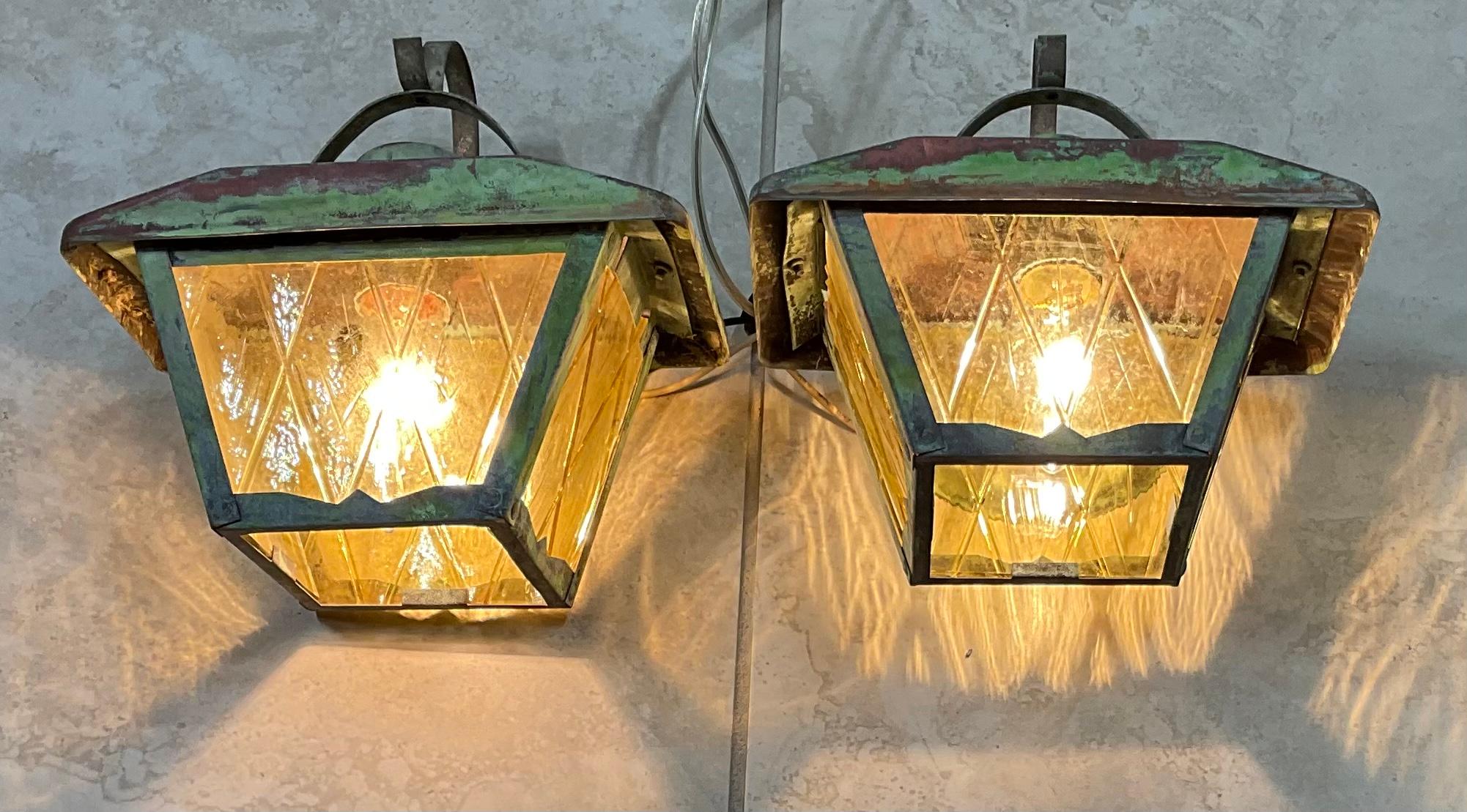 Elegant pair of vintage wall lantern hand crafted from brass with one 60/watt light each. Art glass on three sides.

Beautiful decorative pair of lantern indoor or outdoor.
 