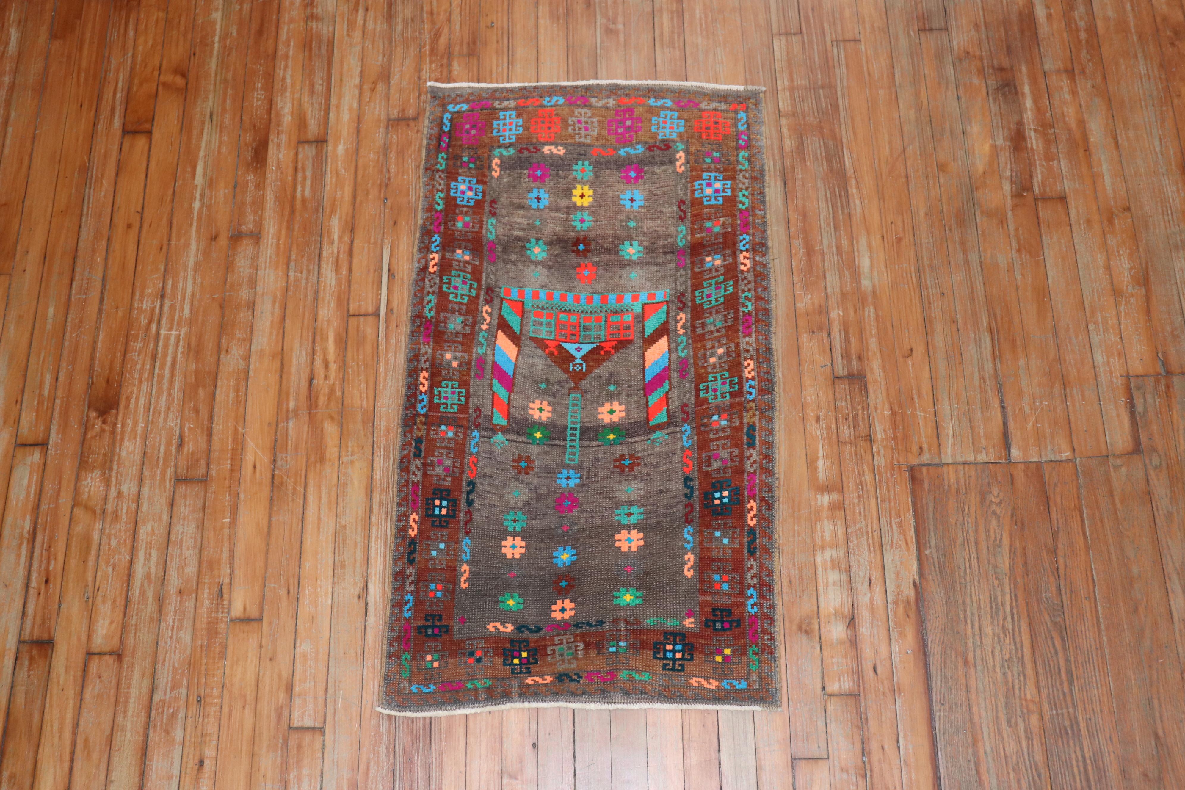 A vintage Anatolian Turkish rug mat with a brown field, cotton accents in electric blue, pink, teal, green, turquoise and orange

Measures: 2'2' x 3'11