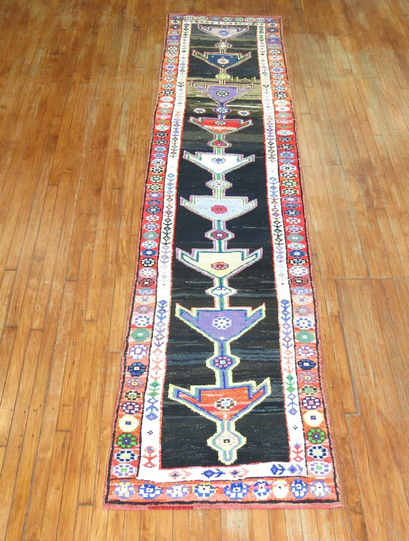 A fun Turkish Anatolian runner with a flashy array of electric colors on a striated charcoal brown and gray color ground. Bright red, orange, purple and neon green accents featured, mid-20th century.

Measures: 2'10