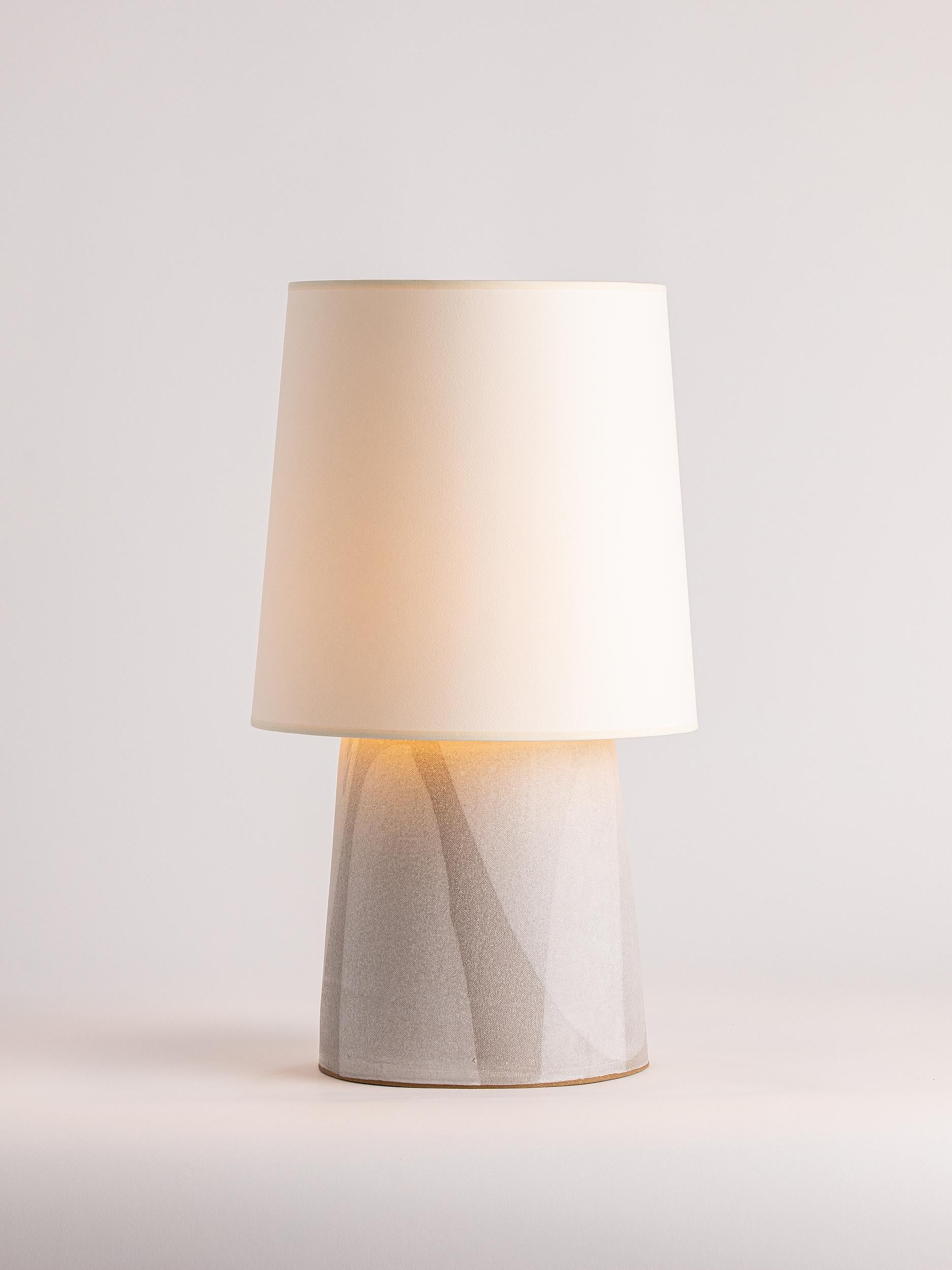 Nuestra lámpara de sobremesa Funnel de gres está hecha a mano mediante técnicas de construcción en bloque.

ACABADO

- Esmalte de tiza vertido
- Herrajes de latón antiguo
- Cordón de tela beige
- 
- Tono de papel de archivo

ILUMINACIÓN

Provisto de