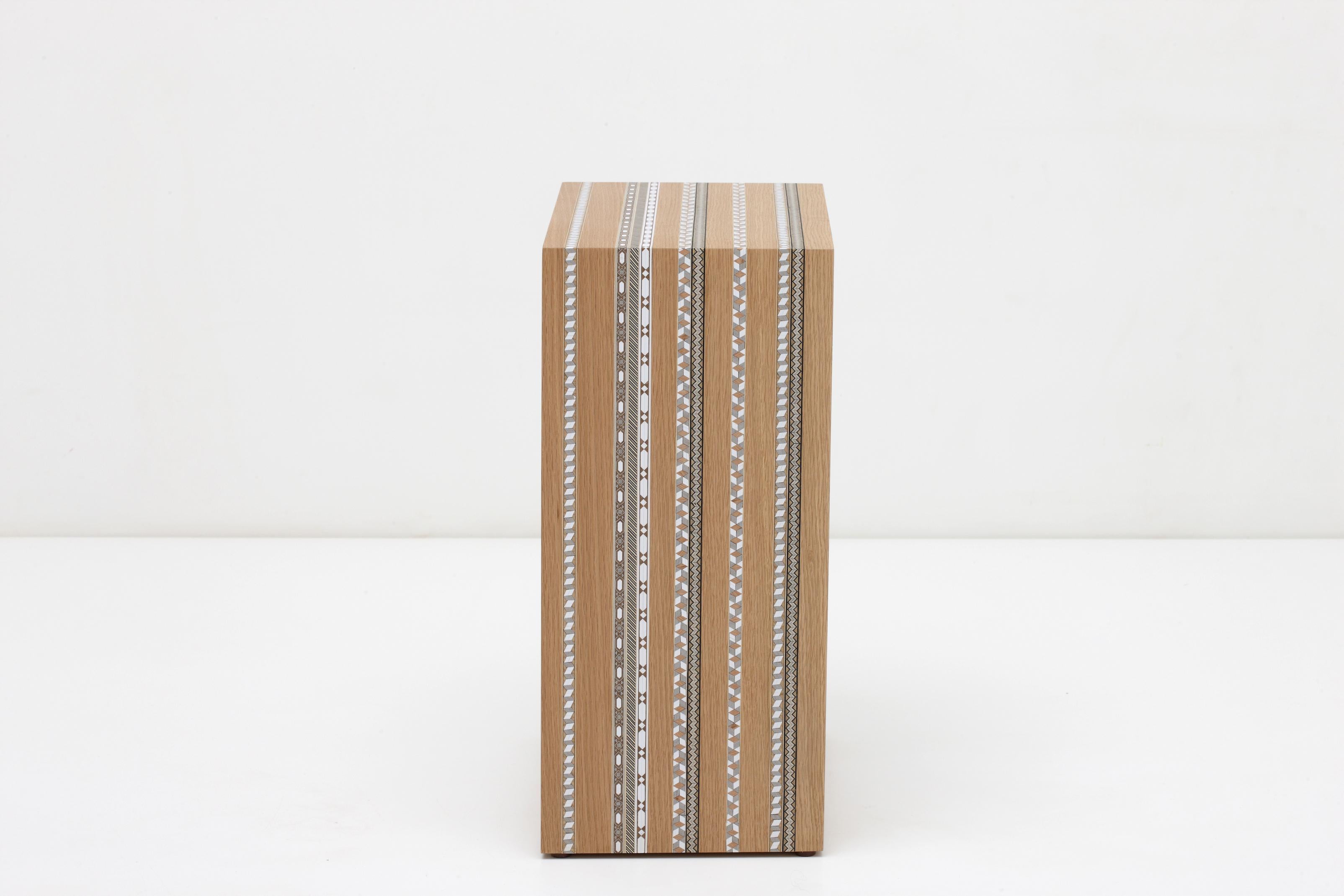 The marquetry strips have a modern playful effect on the simple C-tables.