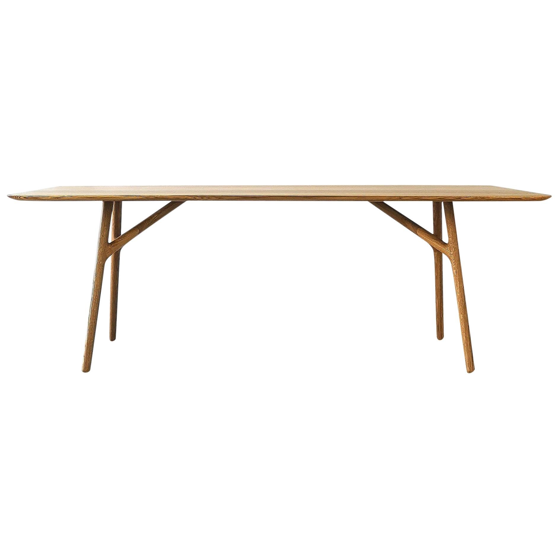 The Furcula by Izm Design is an elegantly handcrafted dining table featuring a sculpted 