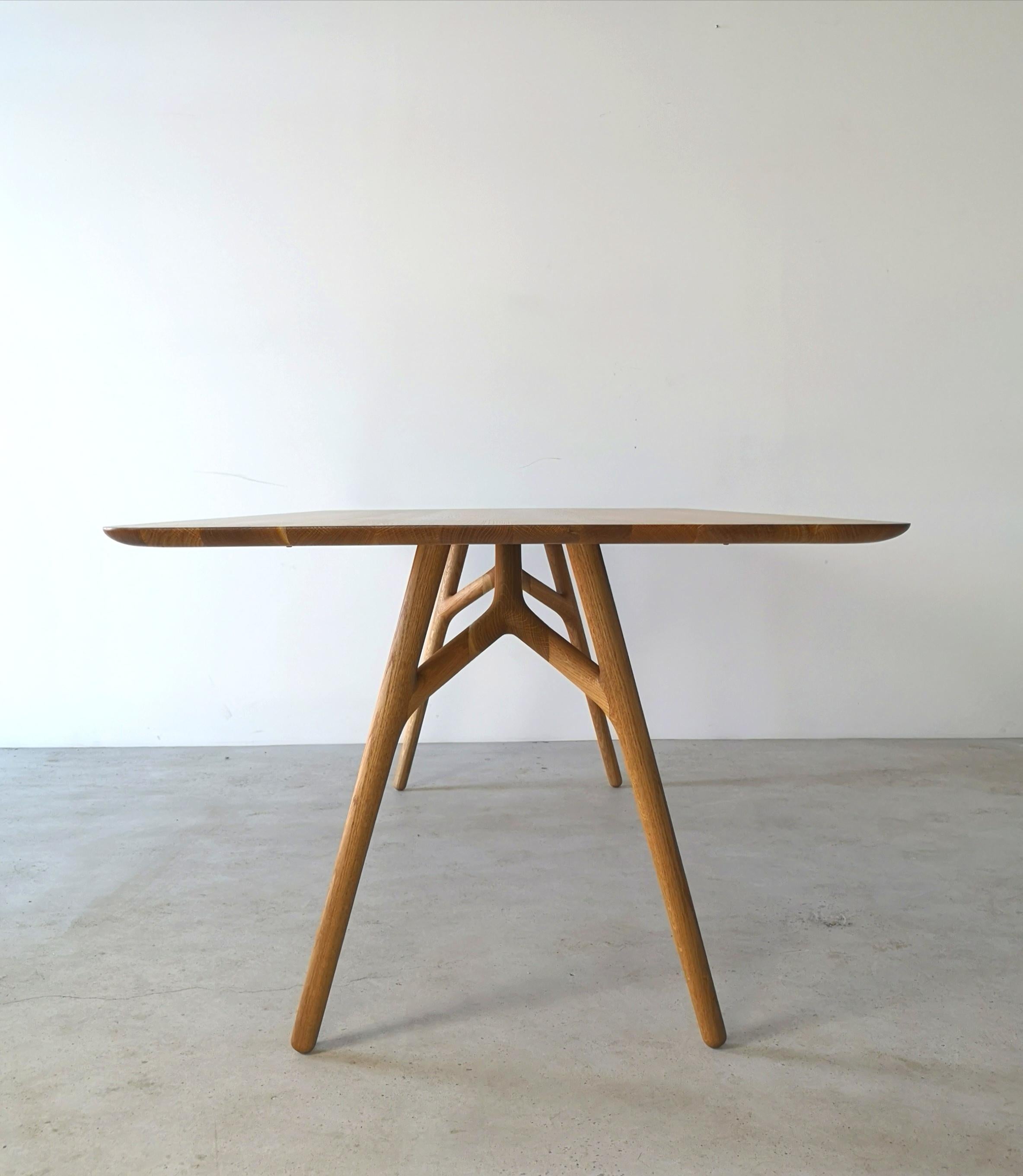 The Furcula by Izm Design is an elegantly handcrafted dining table featuring a sculpted 