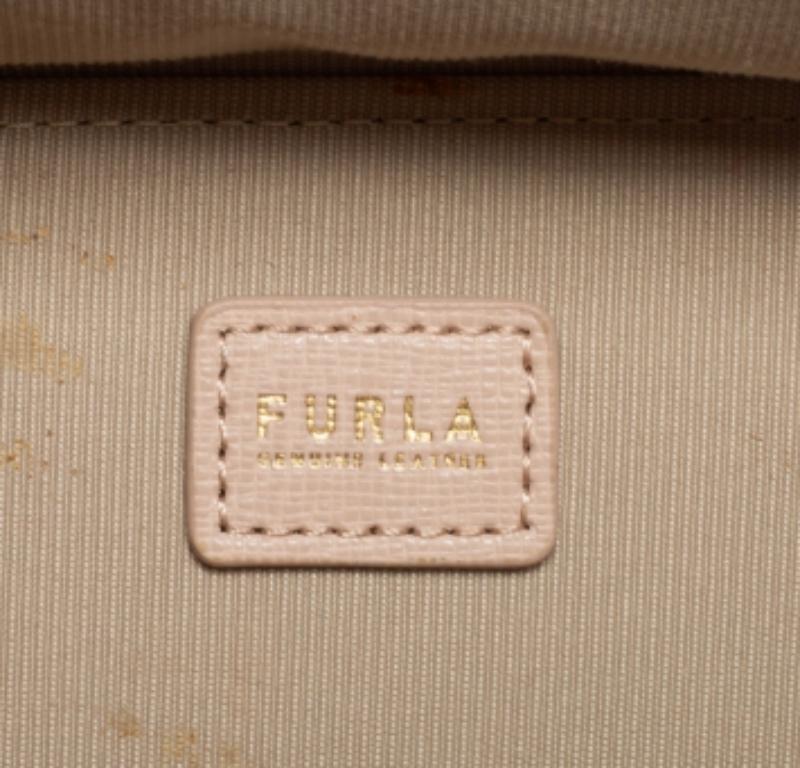 Brillamment conçu, vous ne pouvez pas vous tromper avec ce joli sac de Furla. Chic et sophistiqué, ce sac à bandoulière a un corps en cuir beige pelucheux. Porté par une anse supérieure et une longue bandoulière, il est doté d'une fermeture zippée