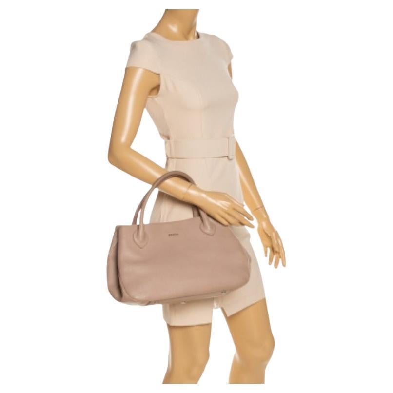 Finely crafted from beige leather, and shining with luxury is this beautiful tote by Furla. It comes with a nylon interior to store your essentials and two handles on top. You truly deserve to have a well-made creation like this one.