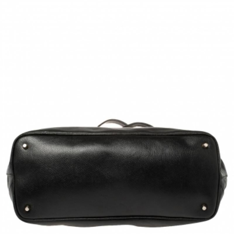 This Furla tote is beautiful in so many ways. From its design to its structure, the leather bag exudes charm and high fashion. It flaunts a black color, front envelope flap, and two top handles. The bag is complete with a spacious fabric interior
