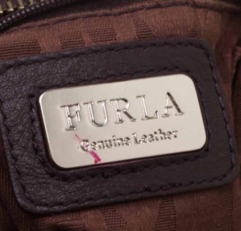 Die aus Leder gefertigte Tasche ist perfekt auf die neuesten Trends abgestimmt. Der Innenraum ist mit Stoff ausgekleidet, was den Stil unterstreicht. Kombinieren Sie diese Furla-Tasche mit einer schmalen Hose und nudefarbenen Pumps, um die