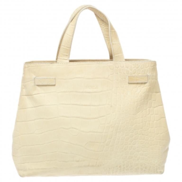 This tote from Furla is finely crafted from croc-embossed leather in a cream shade. It comes with dual handles and a press lock closure. The tote boasts of a spacious fabric-lined interior that can hold all your daily necessities. Simple in design,