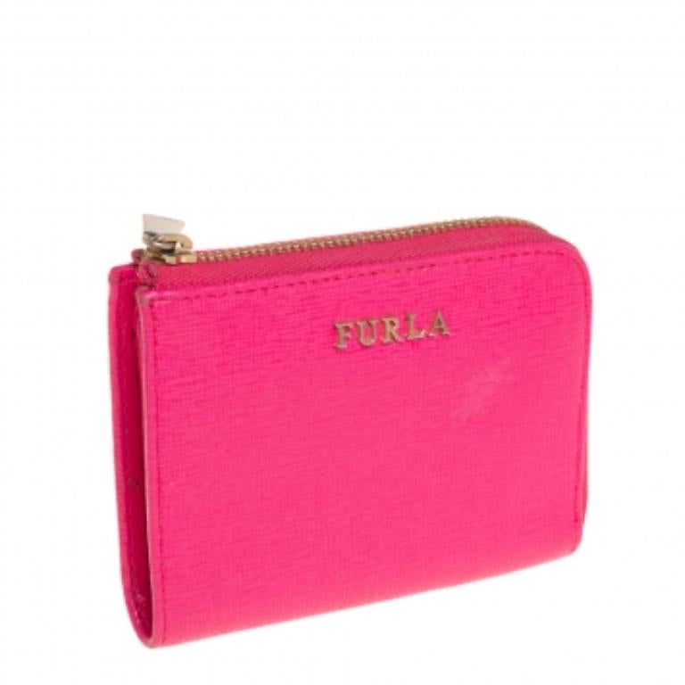 Diese Geldbörse ist eine elegante Kreation aus dem Hause Furla. Dieses Portemonnaie ist aus hochwertigem Leder gefertigt und daher sehr langlebig. Mit diesem Portemonnaie in einem auffälligen Rosaton können Sie Ihre wichtigsten Utensilien mühelos