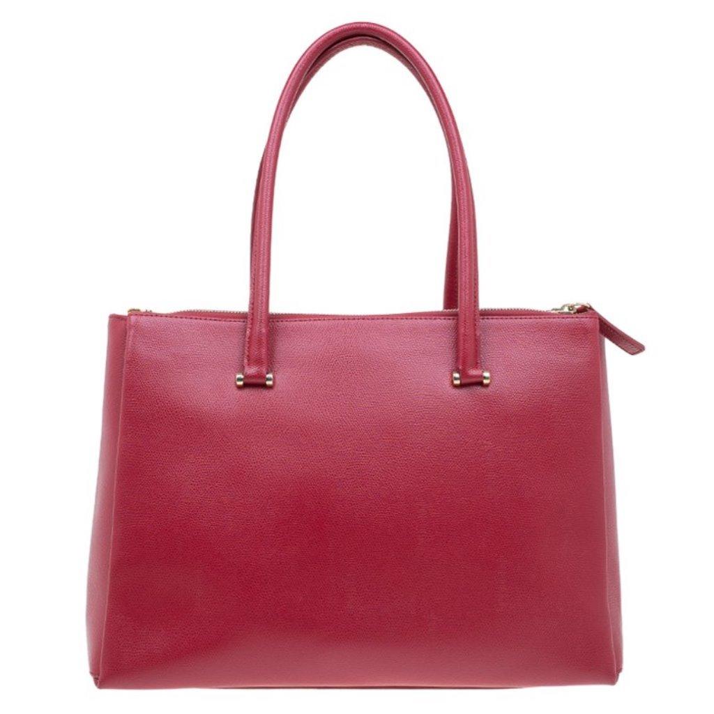 Accent your work attire with fabulous Furla red Lotus tote. It is crafted from red leather with double rolled leather handles, and a front Furla gold-tone logo. The interior houses a zipper pocket and an open pocket that are lined with fabric. The
