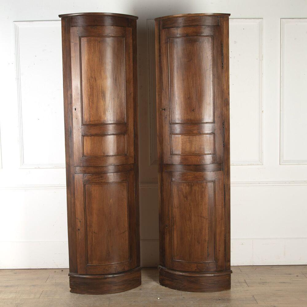 Pair of 20th Century French simulated mahogany corner cupboards.
Of lovely scale and proportions, these cupboards exhibit the most wonderful original rich patina.
The top section features a curved shelf that is perfect for displaying items. The