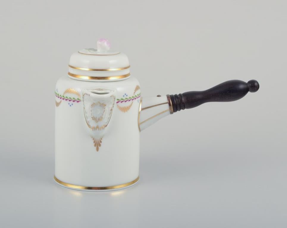 Fürstenberg, Deutschland. Schokoladentopf aus Porzellan mit einem gedrechselten Holzgriff. Blumenknauf auf dem Deckel. Goldverzierung.
Markiert.
Ca. 1930s.
Perfekter Zustand.
Abmessungen: H 11,0 cm x L 16,0 cm.