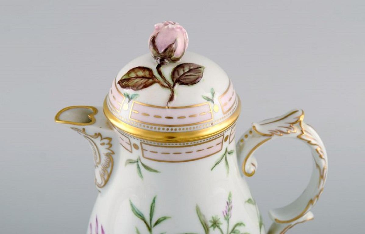 Fürstenberg, Germany. Coffee pot, sugar bowl and cream jug in hand-painted porcelain with flowers and gold decoration. 
Flora Danica style. Mid-20th century.
The coffee pot measures: 22.5 x 16 cm.
The sugar bowl measures: 10 x 9 cm.
In excellent