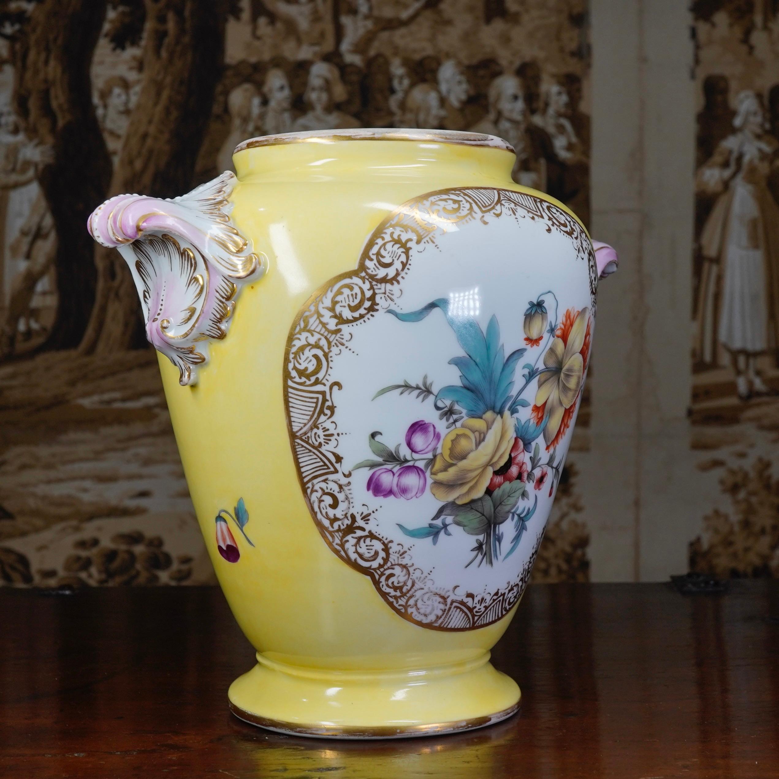 Fine quality Furstenberg footed vase, well painted with a courting couple in a garden to the front, the reverse with a large flower spray, reserved in elaborate gilt frames on a pale yellow ground, with two elaborate shell form handles picked out in