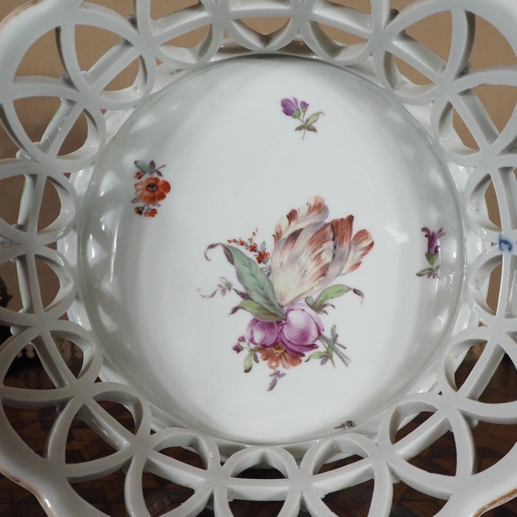 A wonderful Furstenburg pierced basket, the high sides with blue daisyheads at the junctions: a large, beautifully painted tulip and flower group to the base, surrounded by smaller floral sprays. 
Underglaze blue ‘F’ mark inside, impressed NO3 to