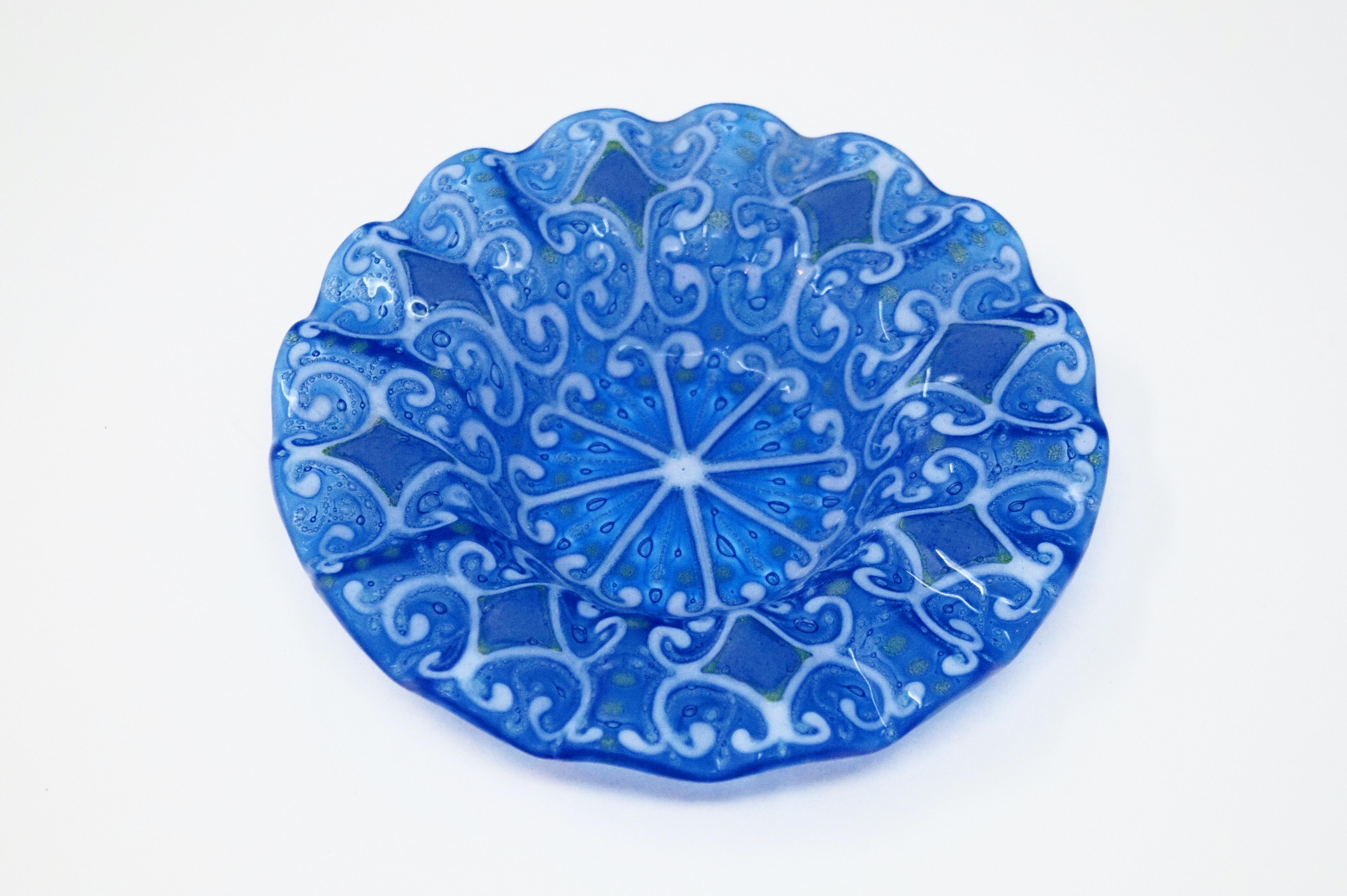 A fused glass decorative bowl or ashtray by Michael and Francis Higgins circa 1950s with classic blue and white motif. 

Signed “Higgins” on verso.

Measures 7