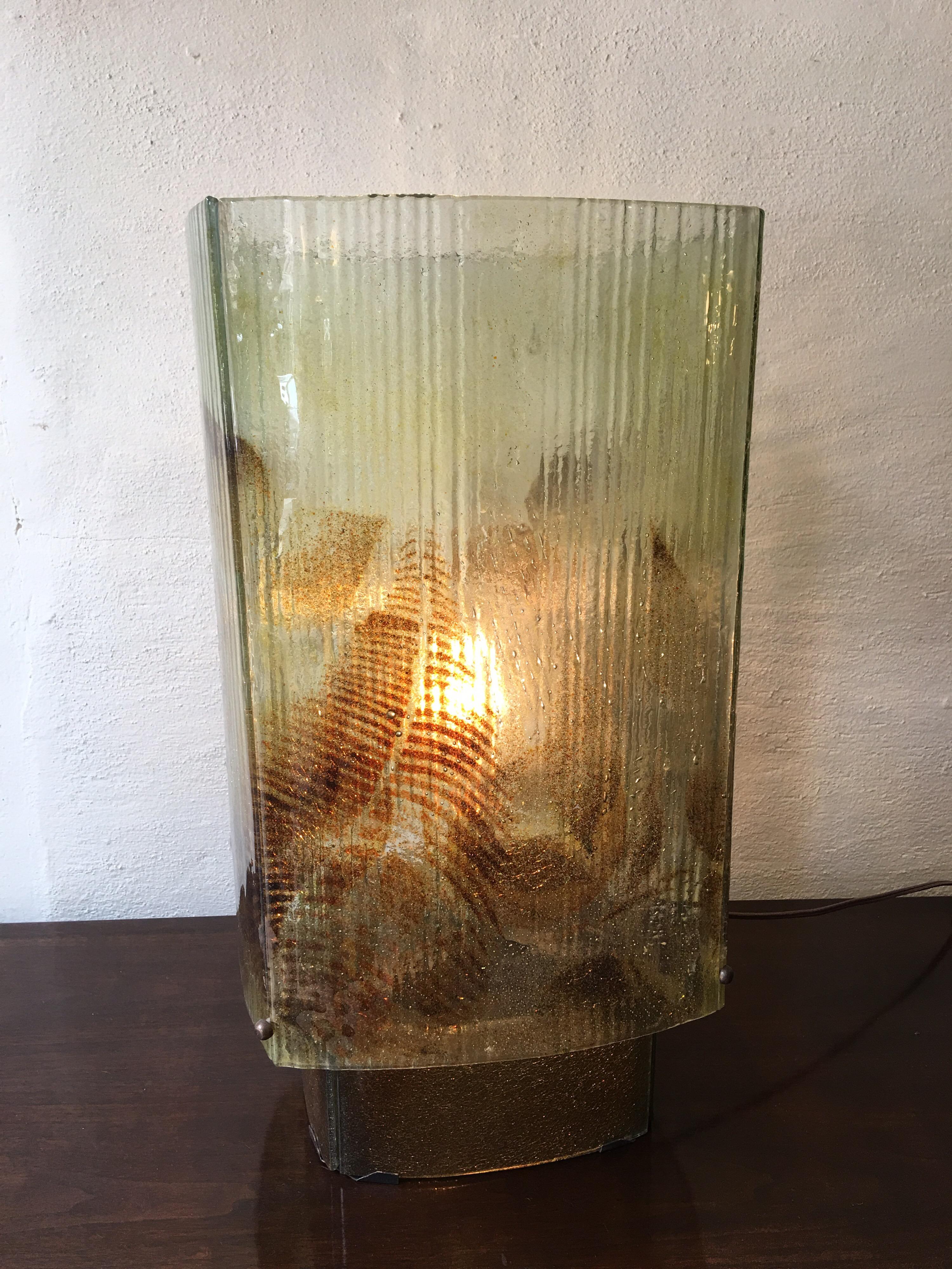Fused glass table lamp made up of 4 slumped curved panels. Body of lamp is raised on a glass pedestal. We have 4 different models all exhibiting a fauna theme. All have been re-wired and are ready to go! Guessing they might be from the 1970s or