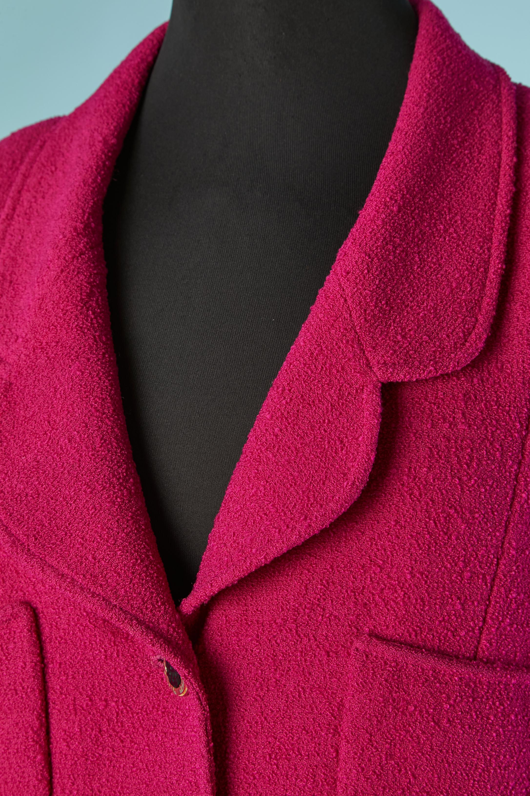 Giacca monopetto in tweed color fucsia. Fodera in raso viola. Spallaccio. Catena sul bordo inferiore interno. Chiusura con bottone e asola con marchio sul centro davanti e sui polsini. 
4 tasche sul davanti. 
TAGLIA 44 (Fr) L 