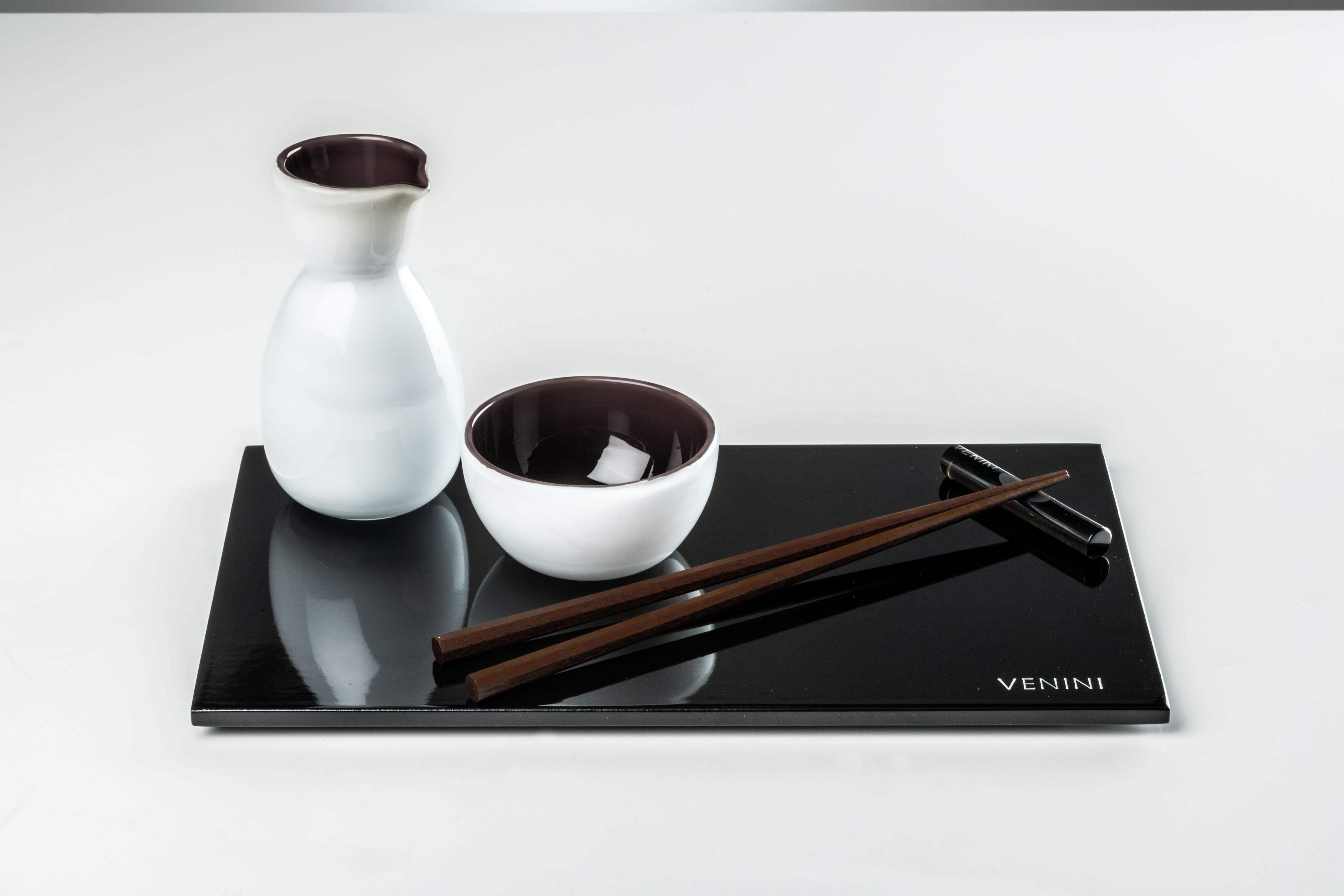 This sushi set designed by Venini is comprised of lacquered plate, wooden chopsticks, cruet, a glass bowl, and a glass chopstick holder.