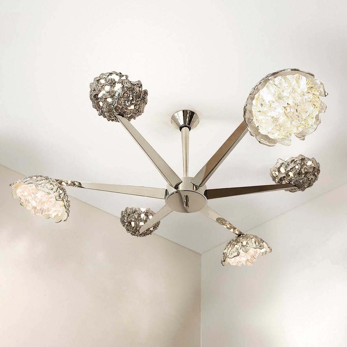 The Fusione ceiling fixture highlights the contrast between organic forms and sleek geometric lines; Cast brass shades with irregular glass crystals sprout from polished V shaped arms. The first images show the fixture in our polished nickel