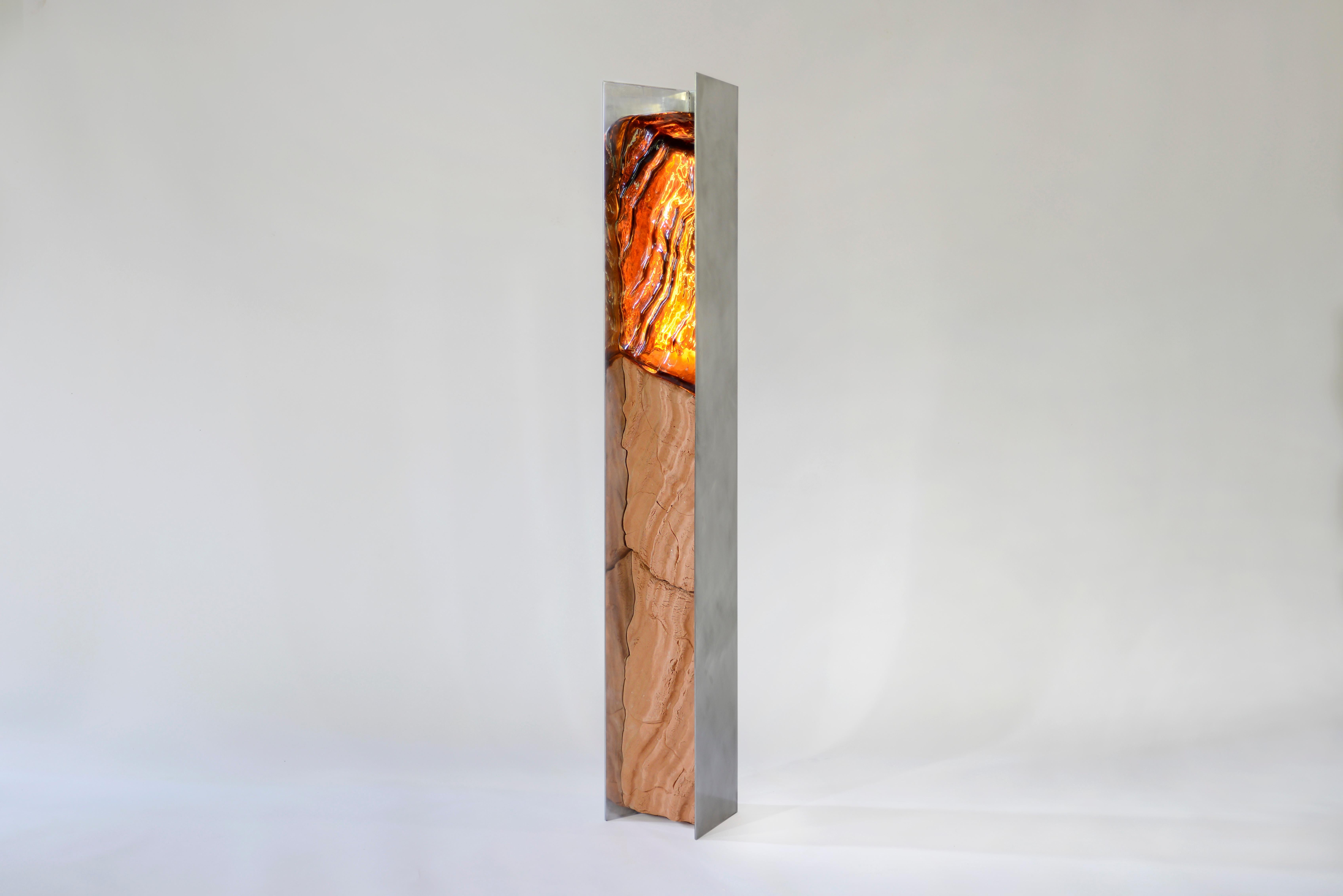 Future Fossils Magma Lamp è una lampada da terra realizzata in gres, alluminio lucido e vetro soffiato spesso. Gli stampi vengono realizzati con una texture intagliata a mano, l'argilla viene pressata in due parti di queste forme e il vetro spesso
