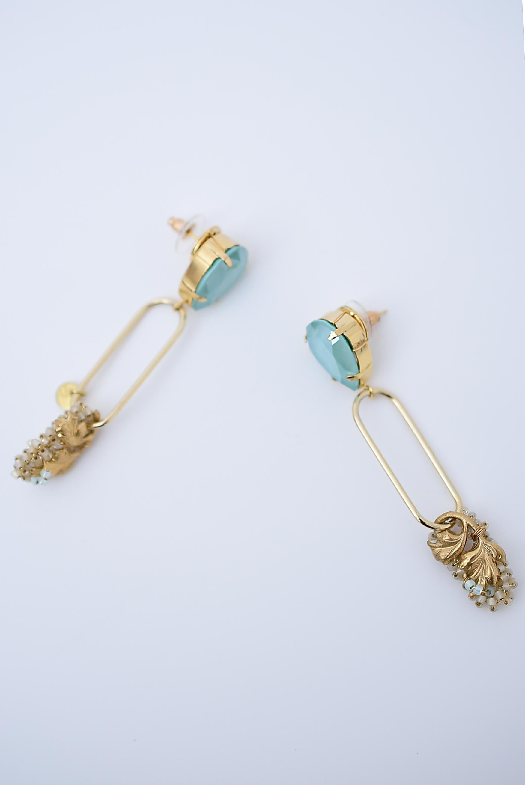 material:1970’s American vintage parts,glass beads,brass,swarovski,stainless
size:length 7cm

A fresh mint green Swarovski is snugly attached to the ear.
The oval part below the Swarovski makes a big swing.
It is long, but the line is delicate, so