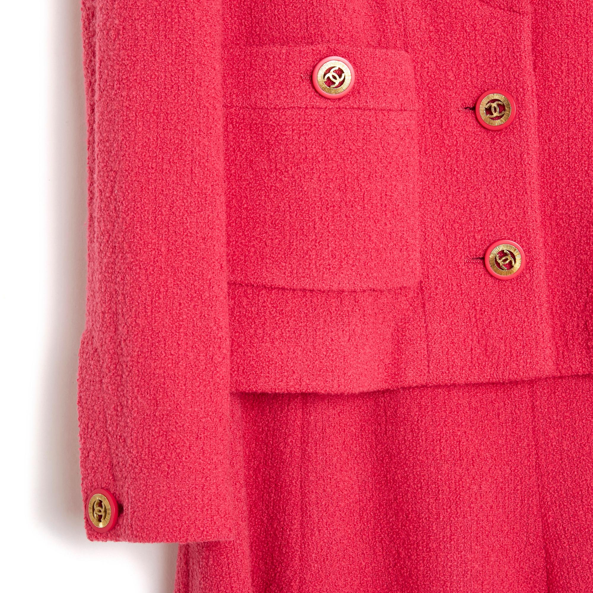Chanel set by Karl Lagerfeld, Fall Winter 1991 collection, in bright pink wool terry, composed of a jacket, round collar closed with 3 CC-branded buttons, 2 patch pockets closed with a coordinated button, like the long sleeves, flared skirt, closed